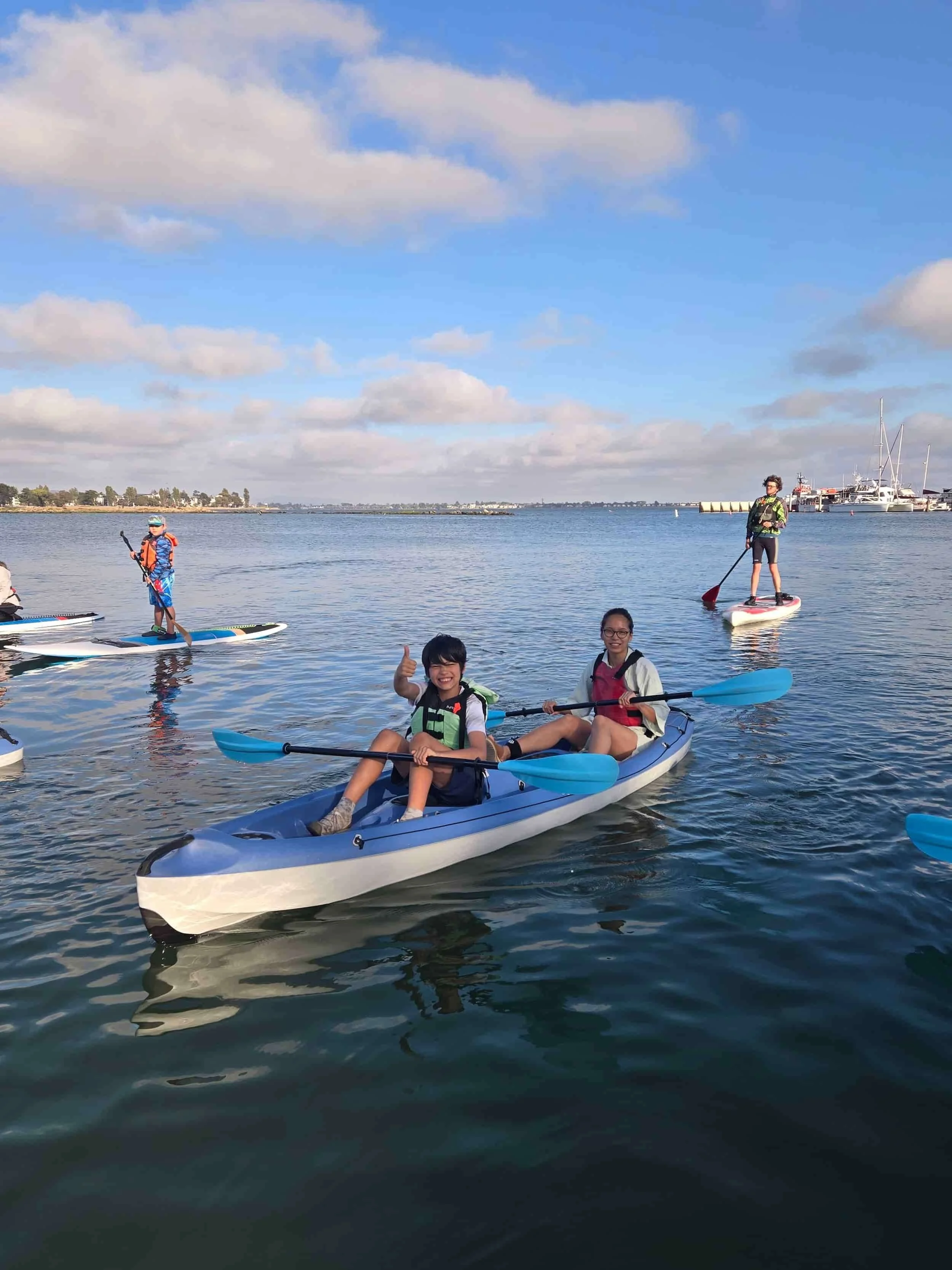 A family kayaking for sunset during Family Paddle Night in Alameda, CA.