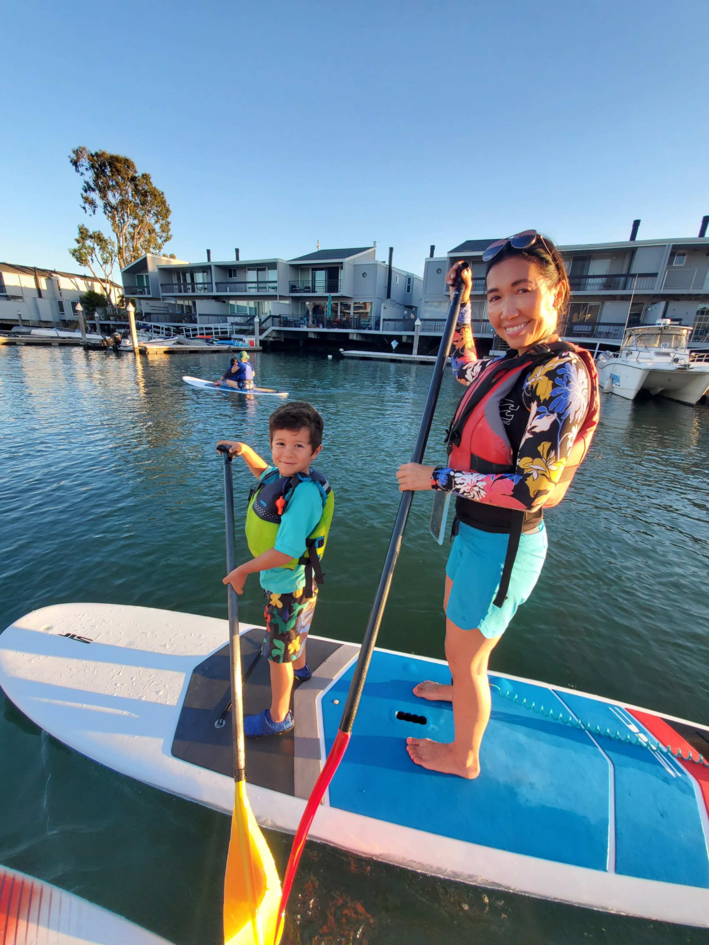 A woman and a boy paddleboarding for Family Paddle Night.