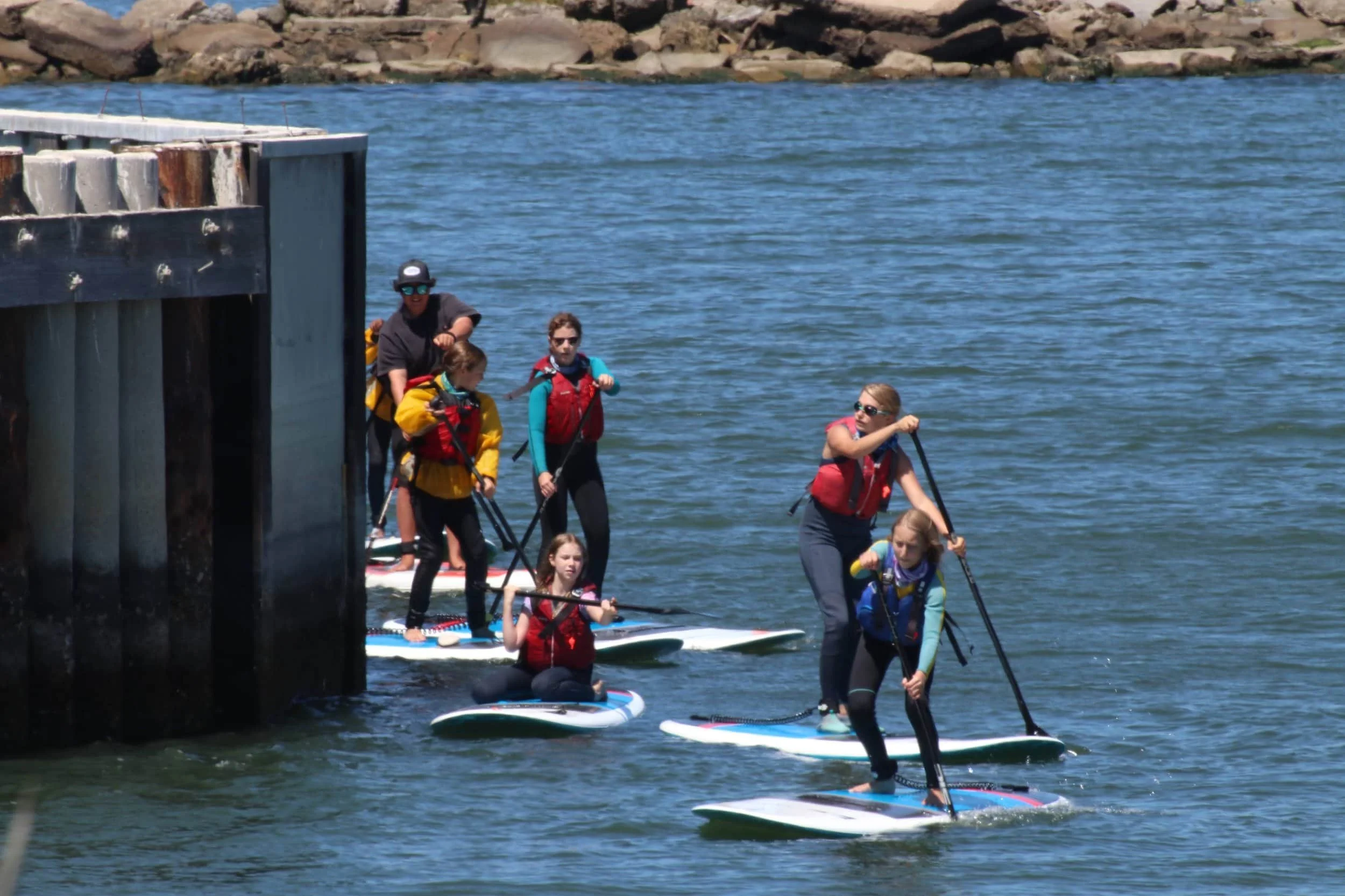 Teens paddleboarding on the water around Alameda.