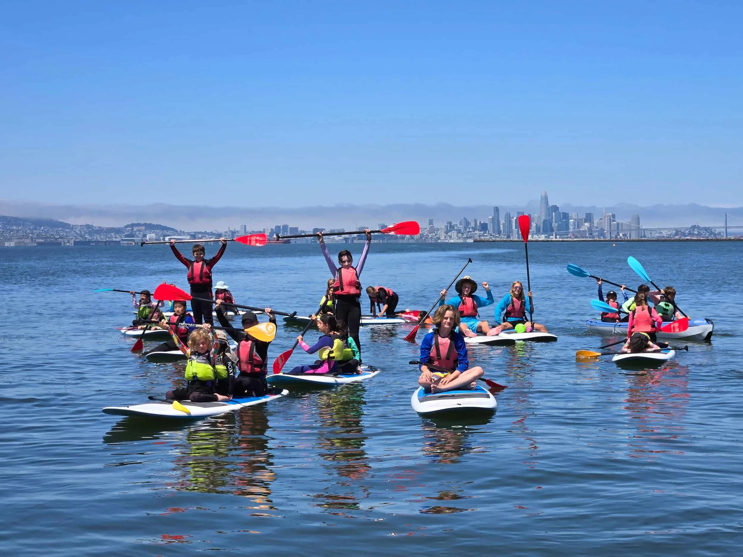Group of kids paddleboarding in Alameda with Gaia Guides Summer Camp.