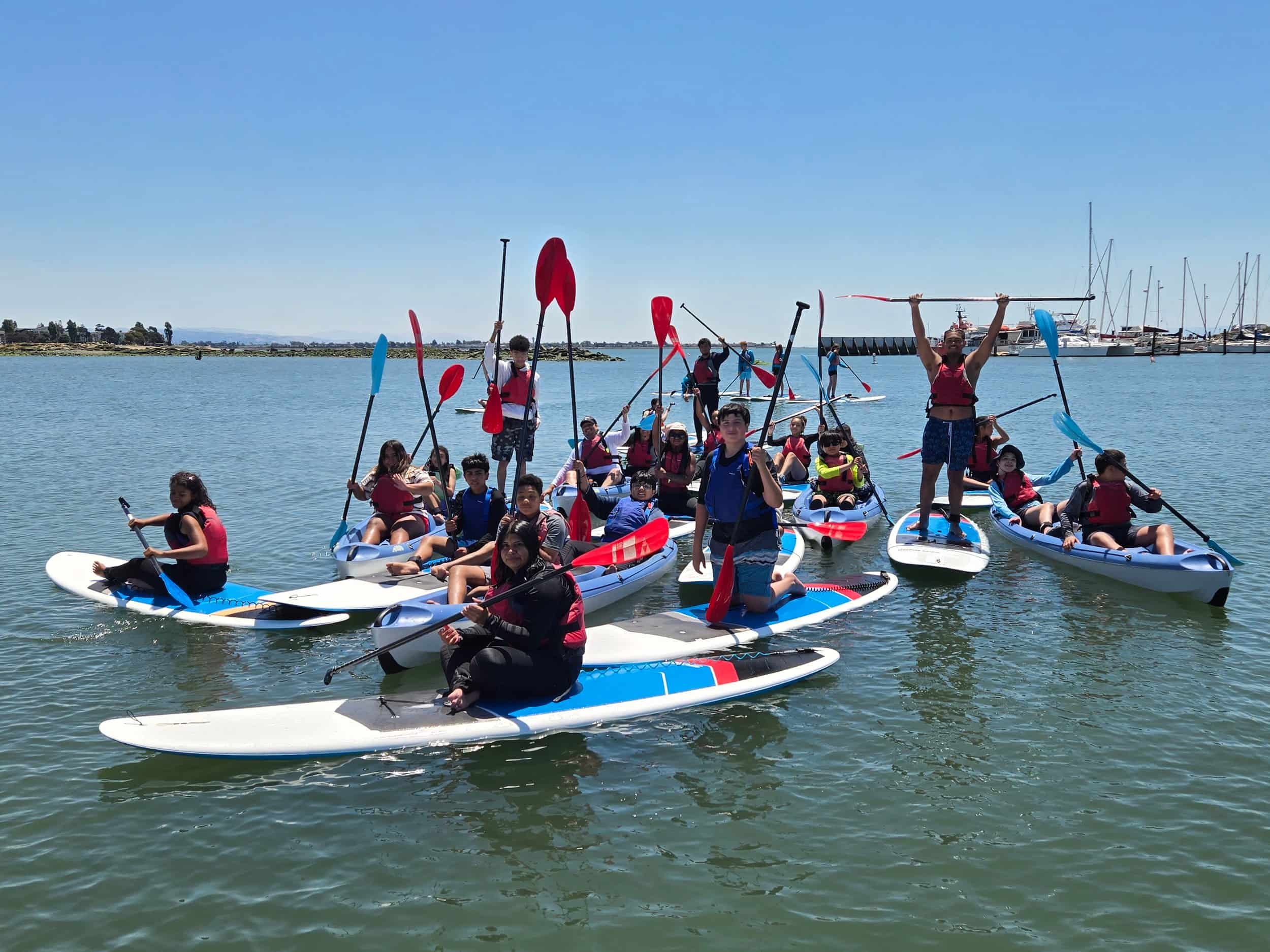 Kids kayaking and paddleboarding for a private group school field trip.