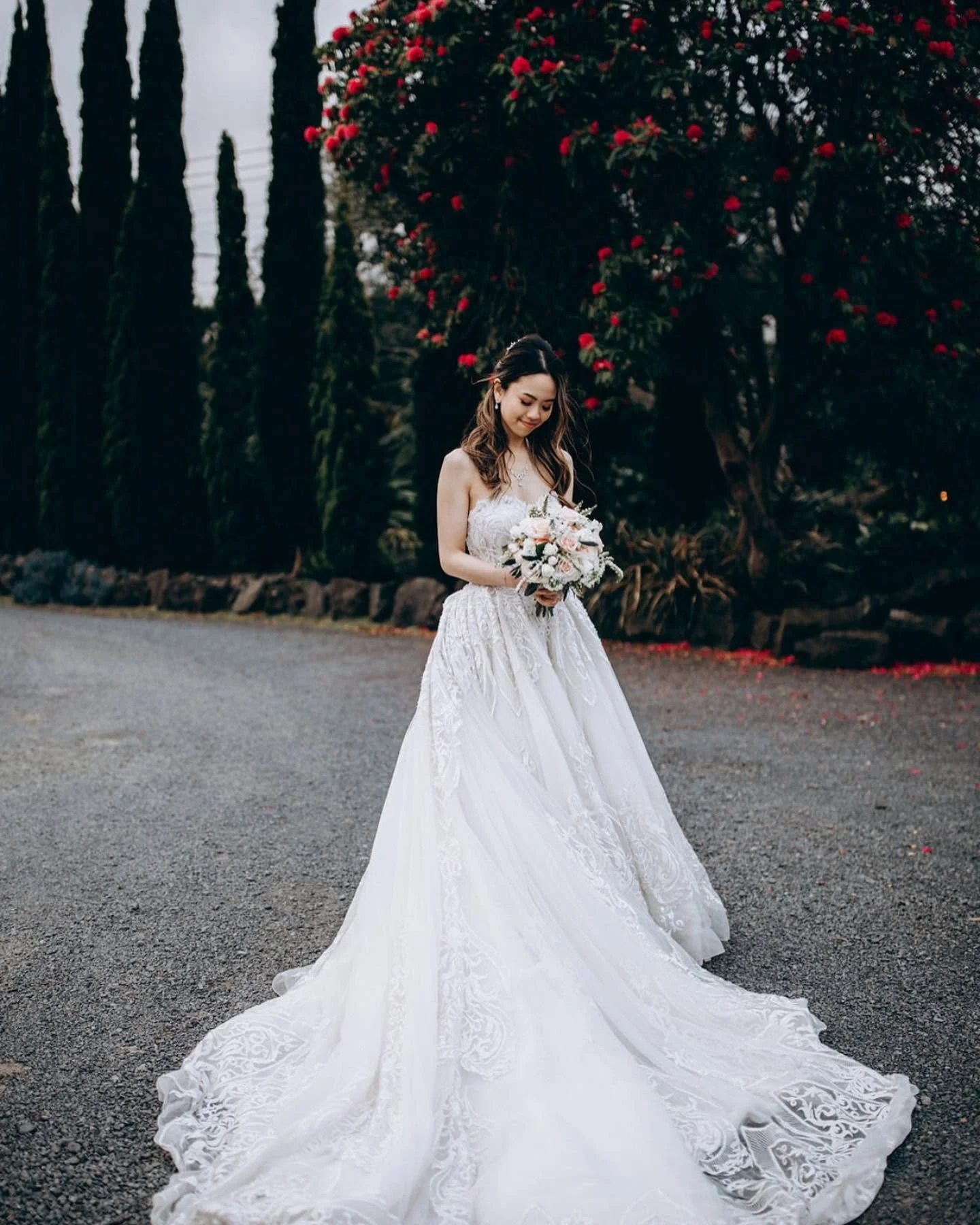 “Bride in elegant white wedding dress holding bouquet outdoors