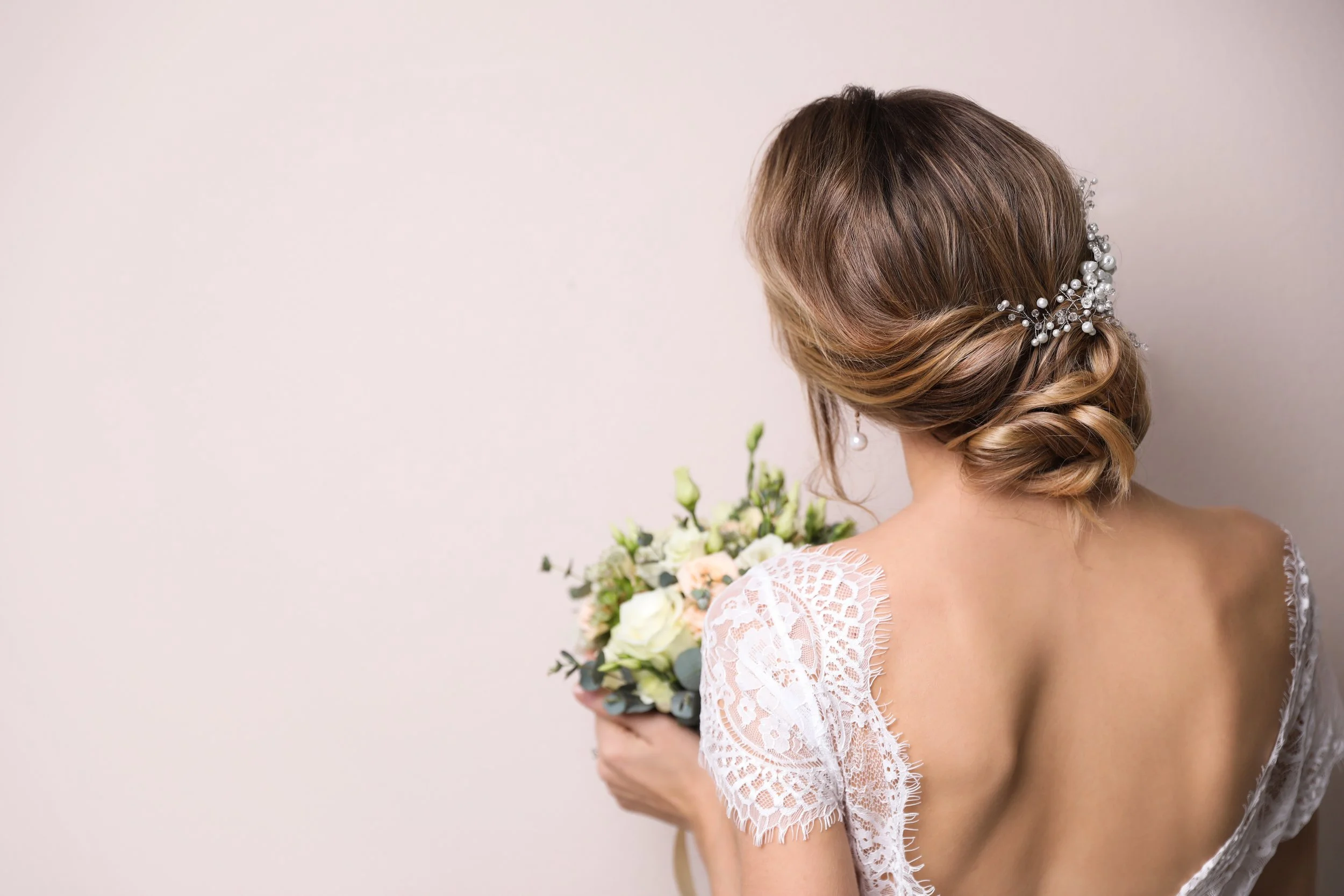 “Elegant bridal updo with hair accessories and wedding bouquet”