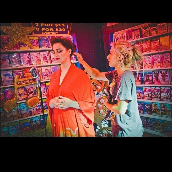 Set with two women, one in an orange robe with makeup for a jazz music video kaz elizabeth makeup artist for glmaour tribe makeup artistry