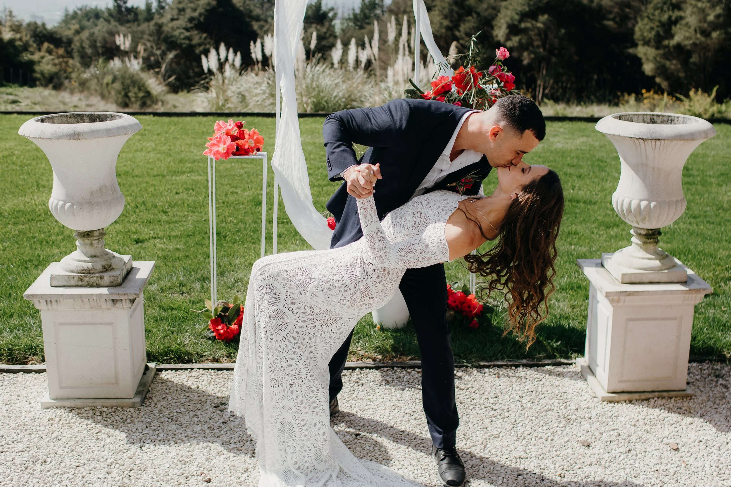 “Bride and groom sharing a romantic wedding kiss outdoors