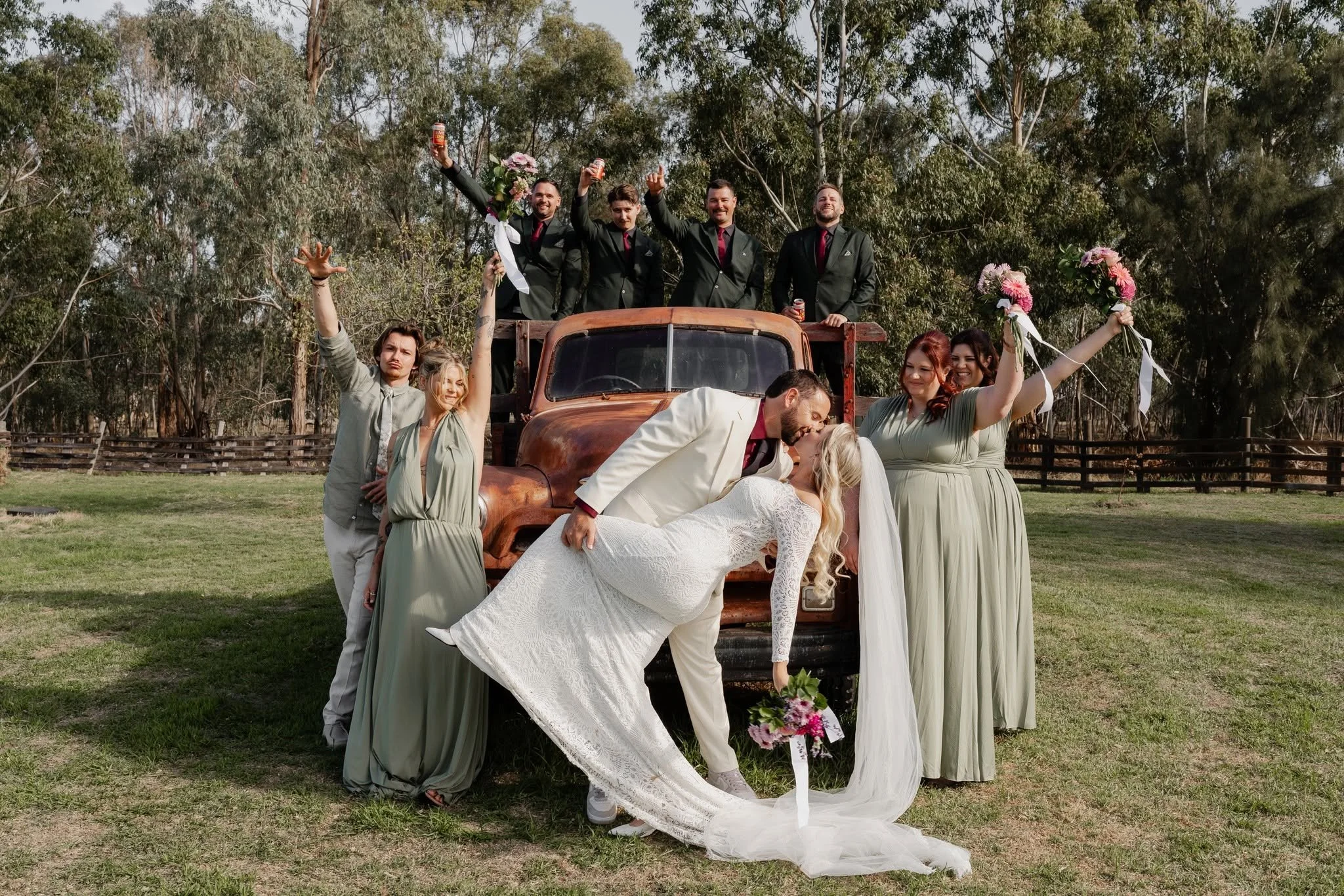 Bride and groom celebrating with their wedding party outdoors