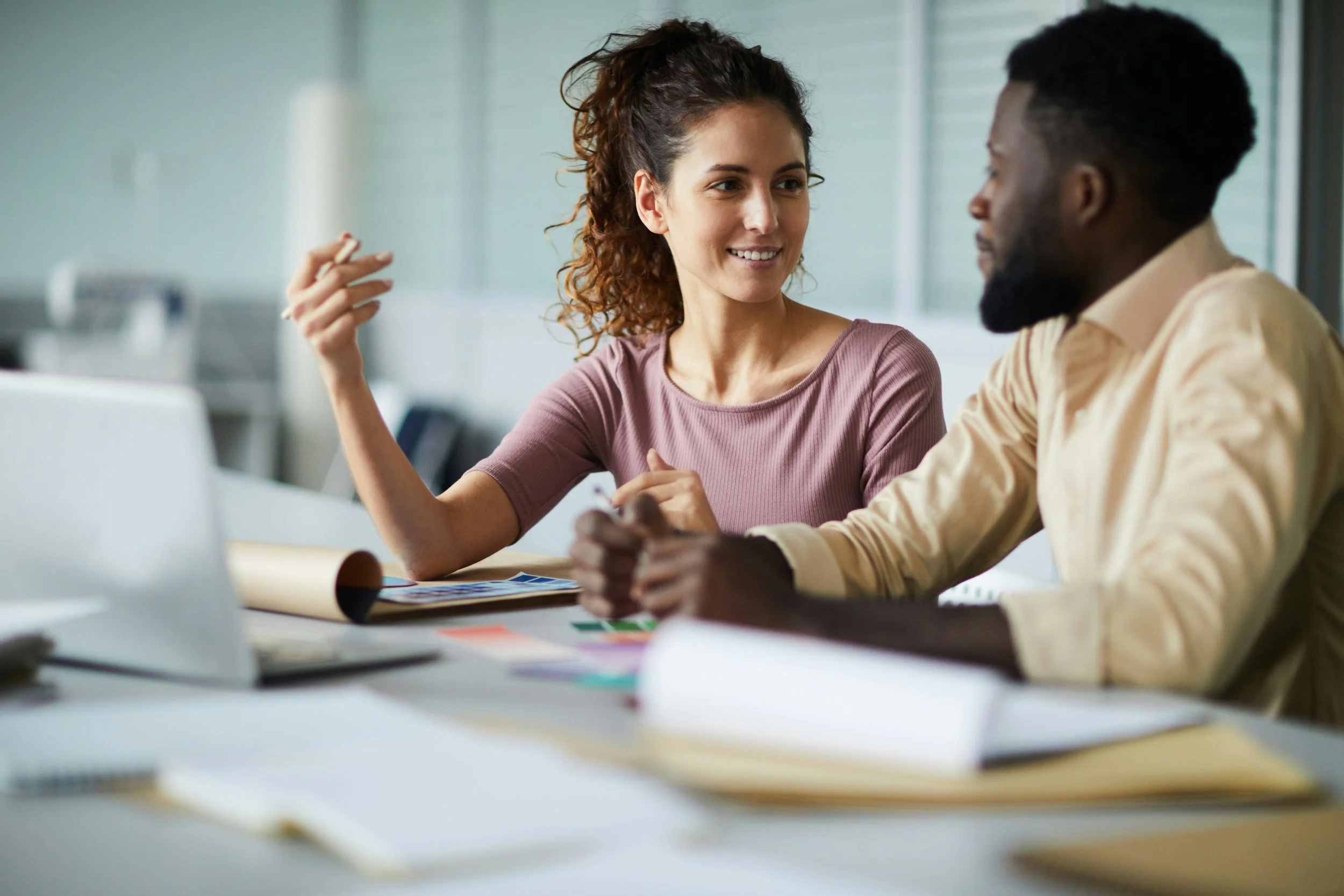 Two business people having a conversation sitting at a desk