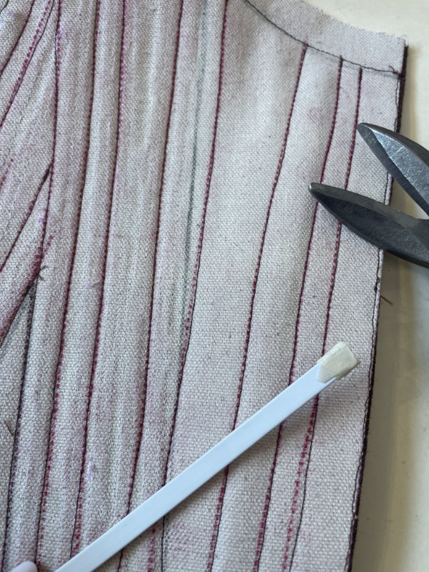Flat steel boning to provide more support and structure at the center front of the bodice where the grommets will be inserted.