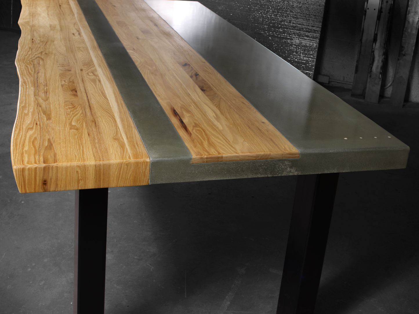 concrete and wood dining table featuring live edge and inlay on durable steel base