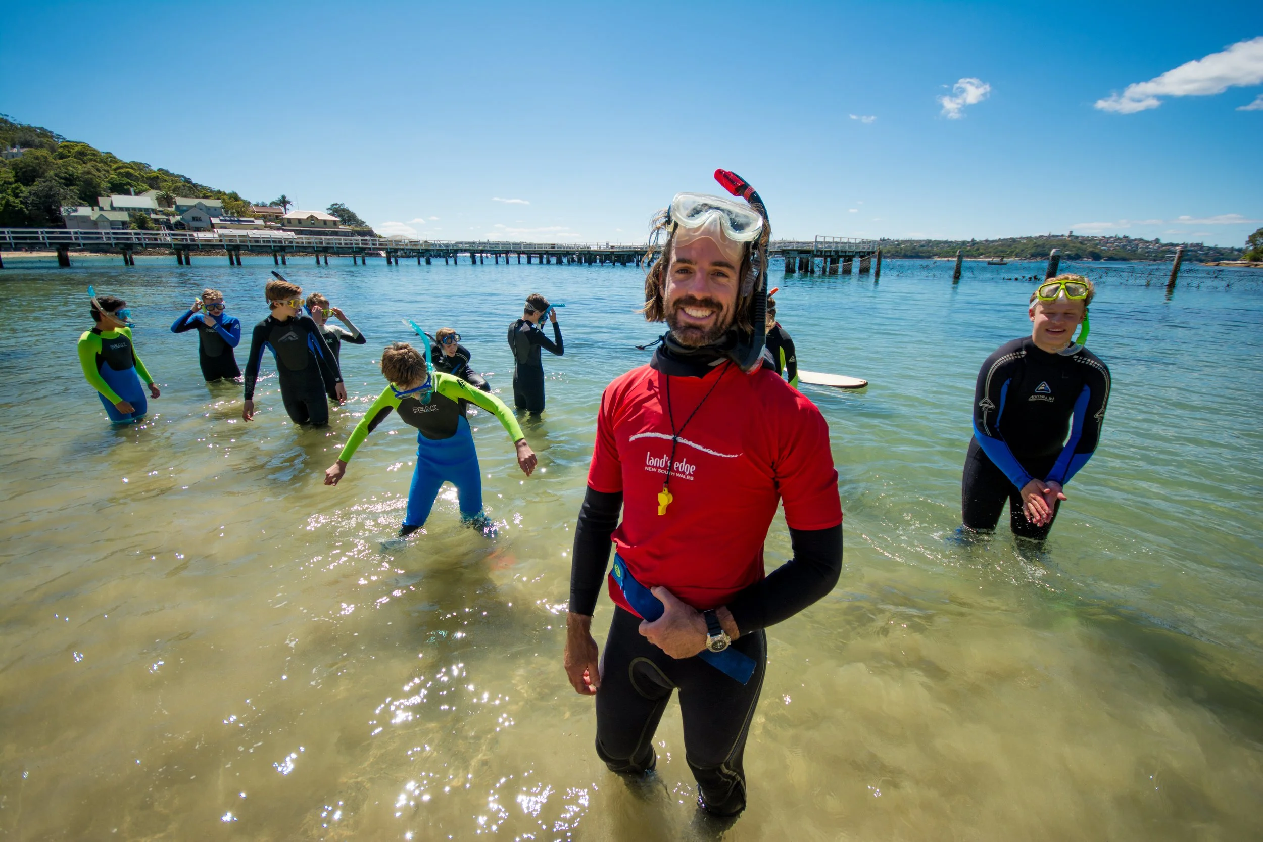 Saltwater School snorkel Instructor and group of kids standing in water at Chowder Bay. Sydney. Land's Edge Foundation