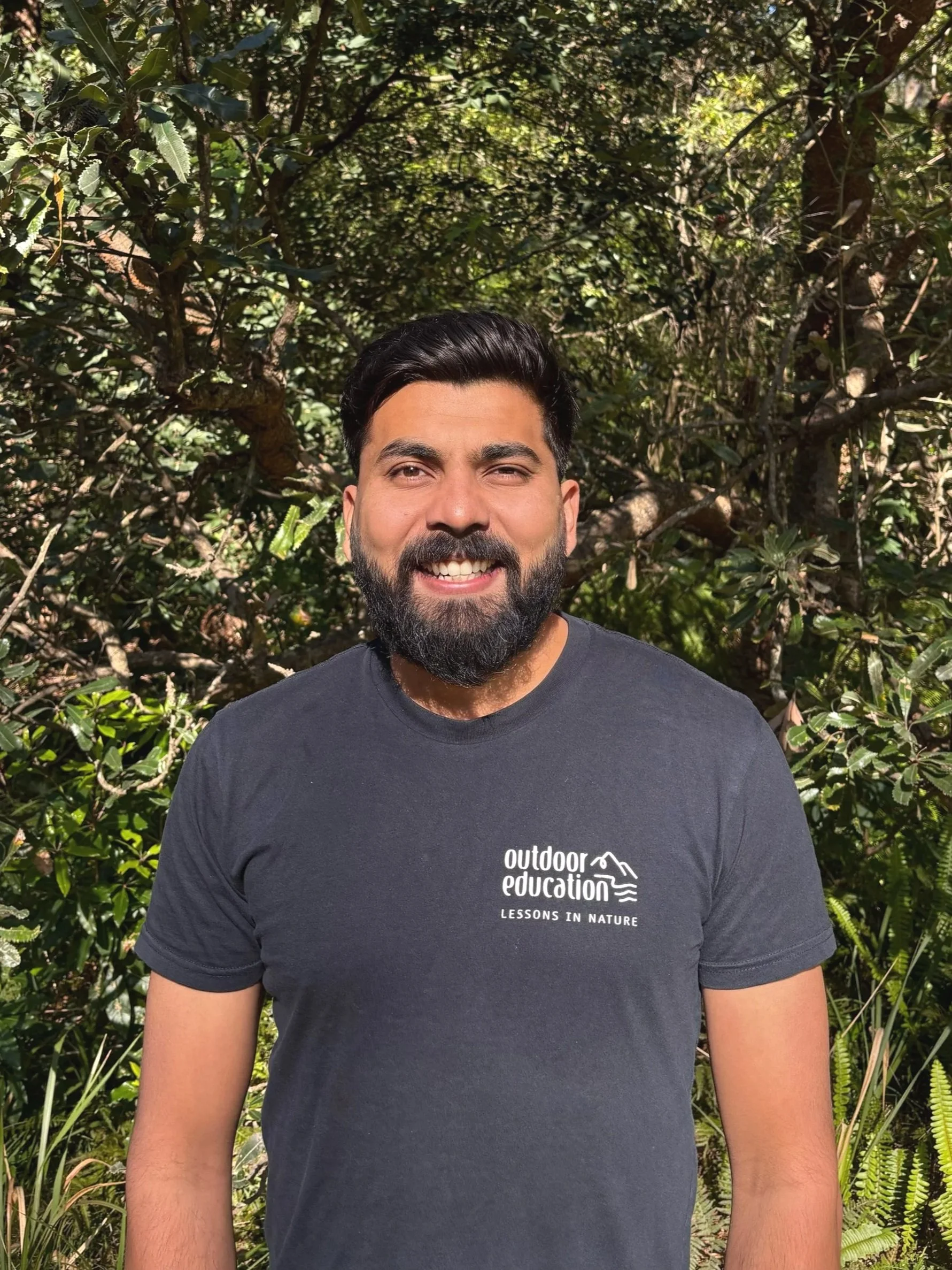 Photo of Samkit Jain with a bushland background, Program Coordinator at Land's Edge Foundation