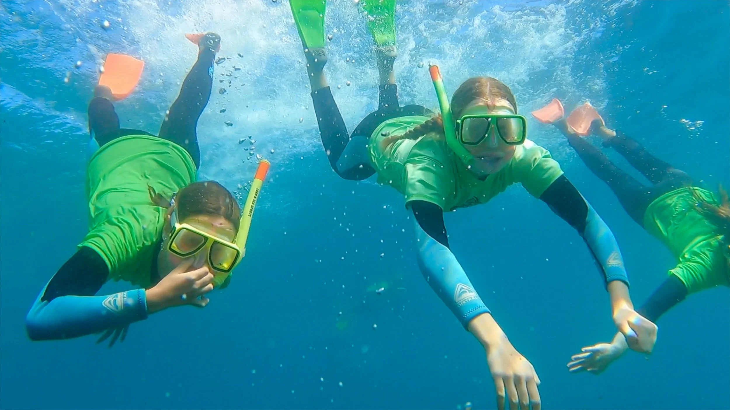 Three kids under water snorkelling