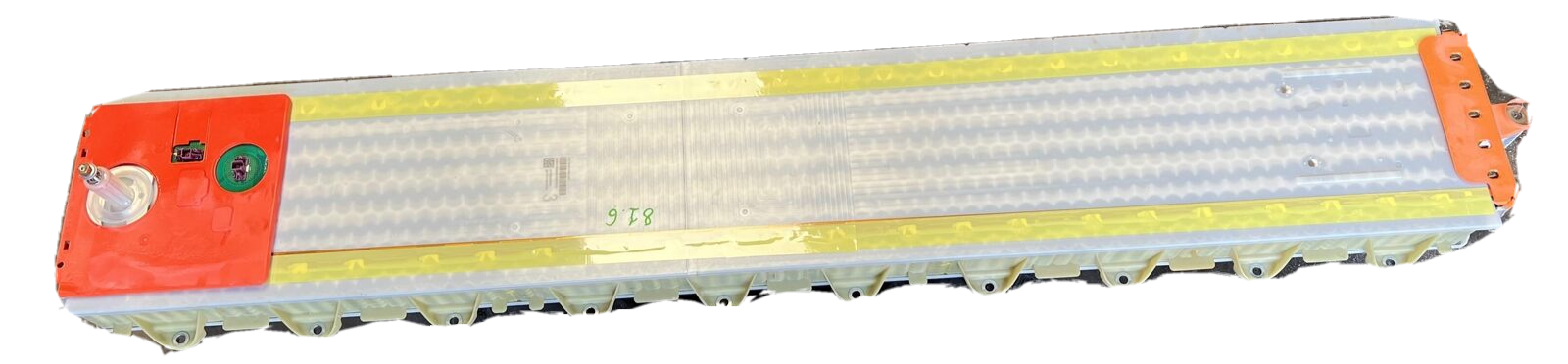 A large rectangular battery with a red and orange top, green and black components, and a yellow warning strip, likely used for industrial or energy storage applications.