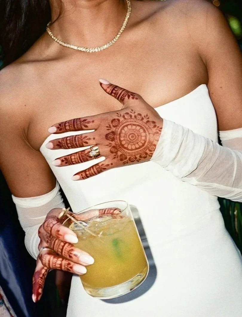 A bride holding a margarita with mendhi on her hands from a fusion wedding at Holly Farm in Carmel, california