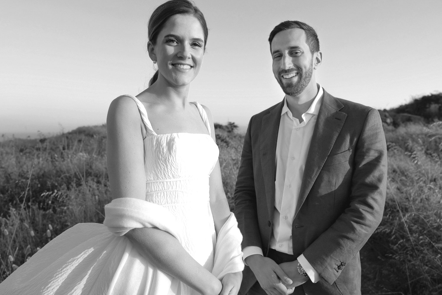 Newlyweds smiling along the rugged Mendocino Coast after their Sea Ranch wedding