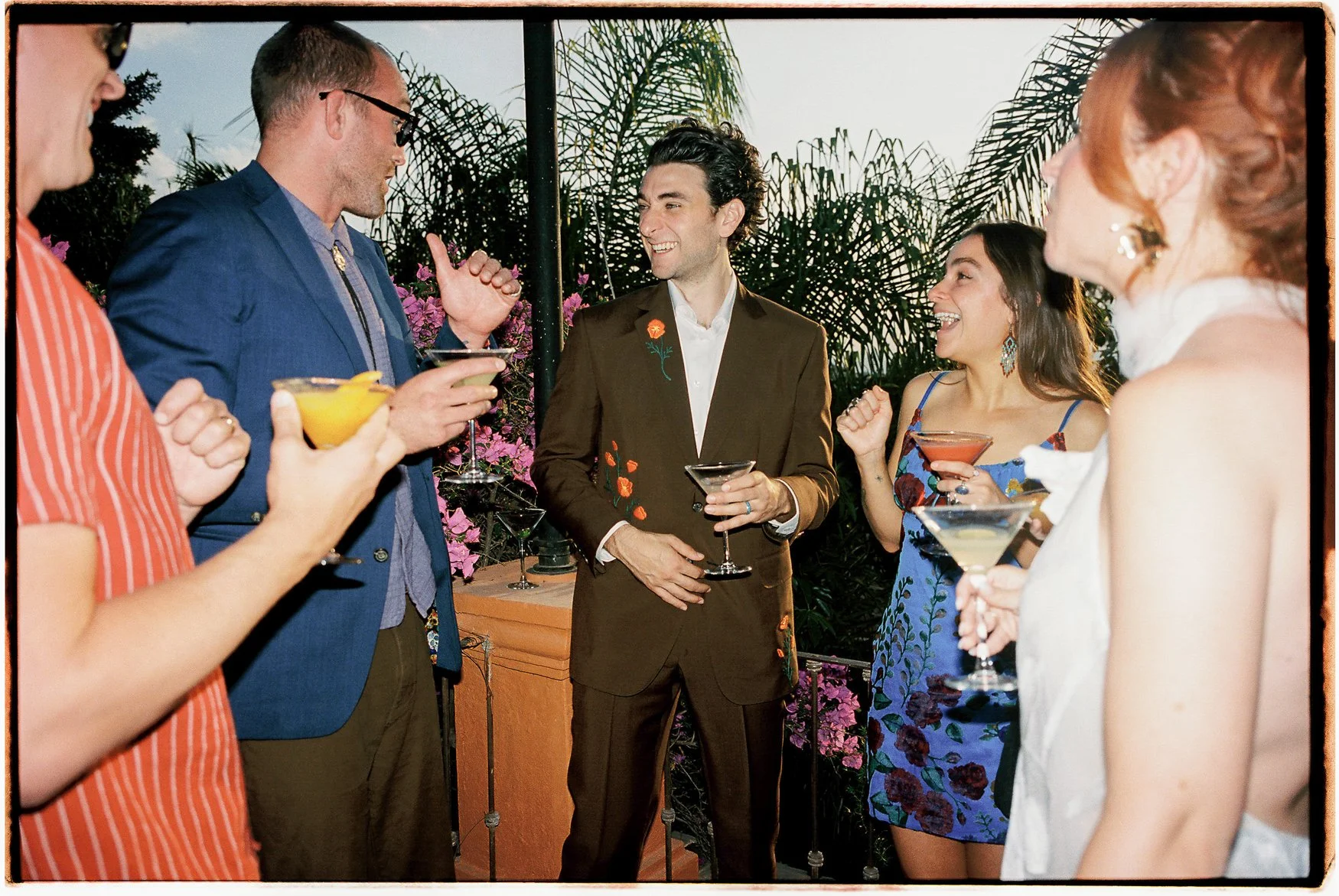 Friends socializing with cocktails at an outdoor garden party