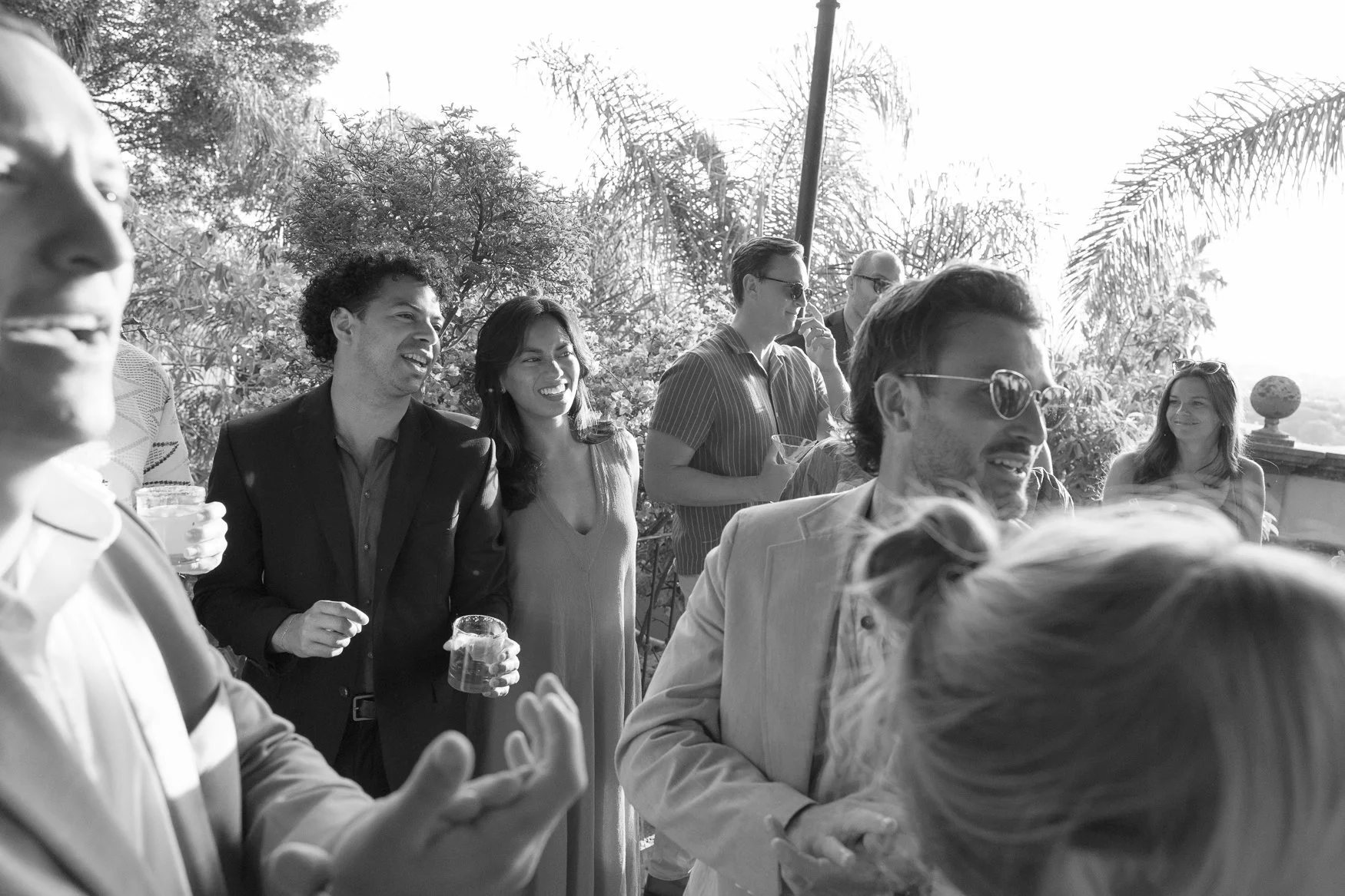 Group of people socializing with drinks at an outdoor garden gathering