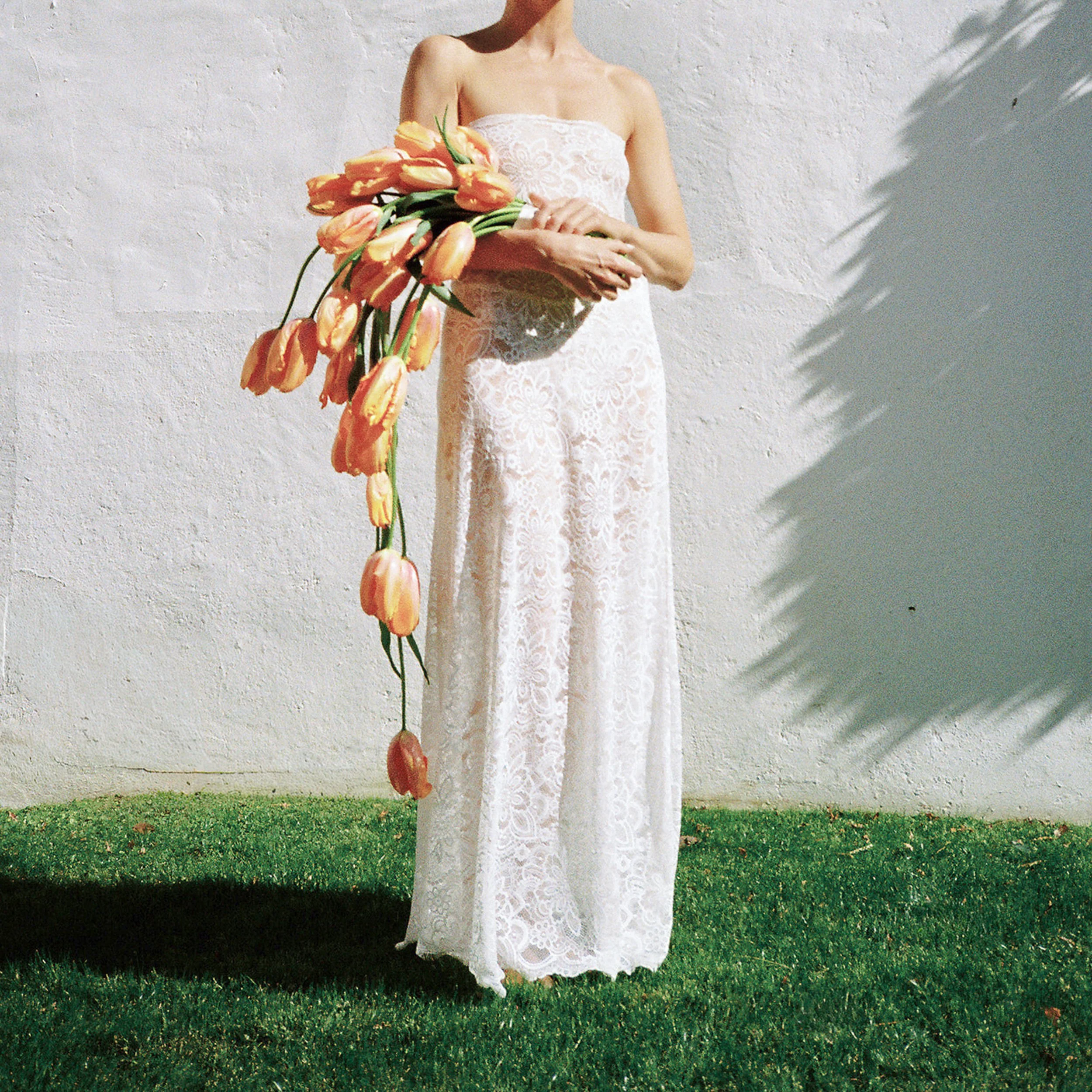 A bride holding her bouquet featuring cascading orange tulips