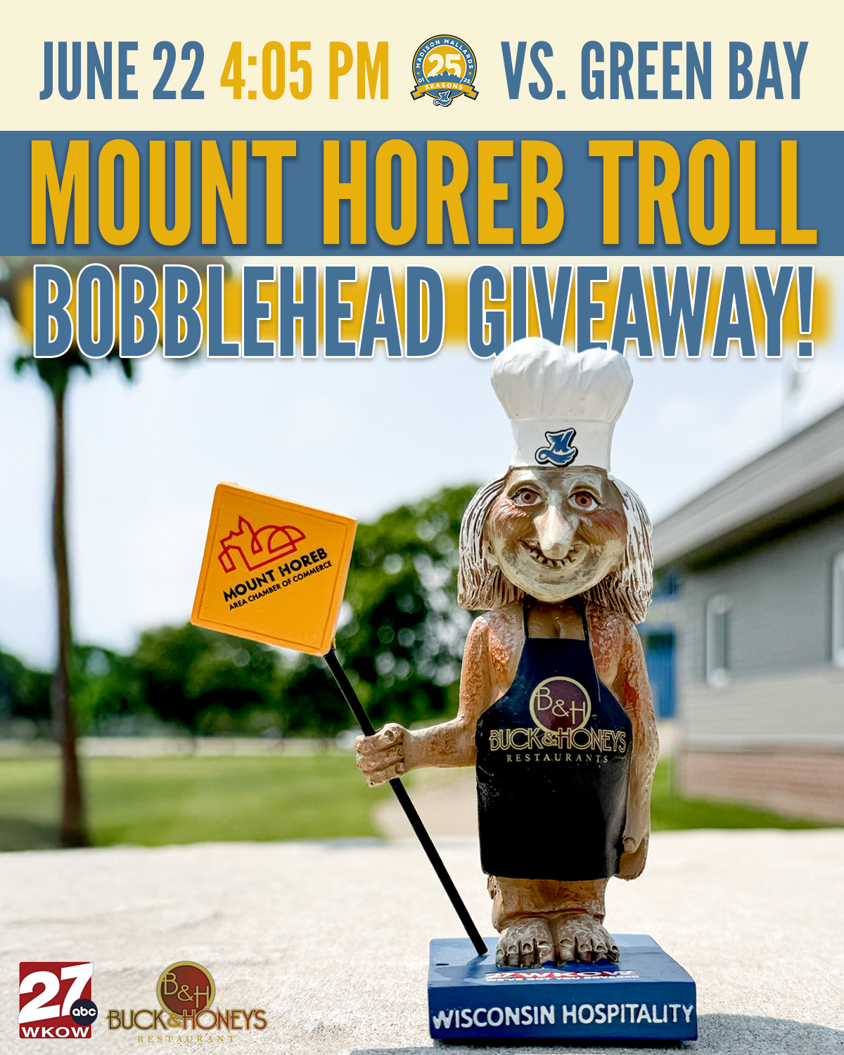 A statue of a troll chef holding a flag with Mount Horeb logo, advertising a Bobblehead Giveaway on June 22 at 4:05 PM, against a background of trees and a building, with logos of WKOW ABC27, Buck & Honey's Restaurant, and Mount Horeb Area Chamber of