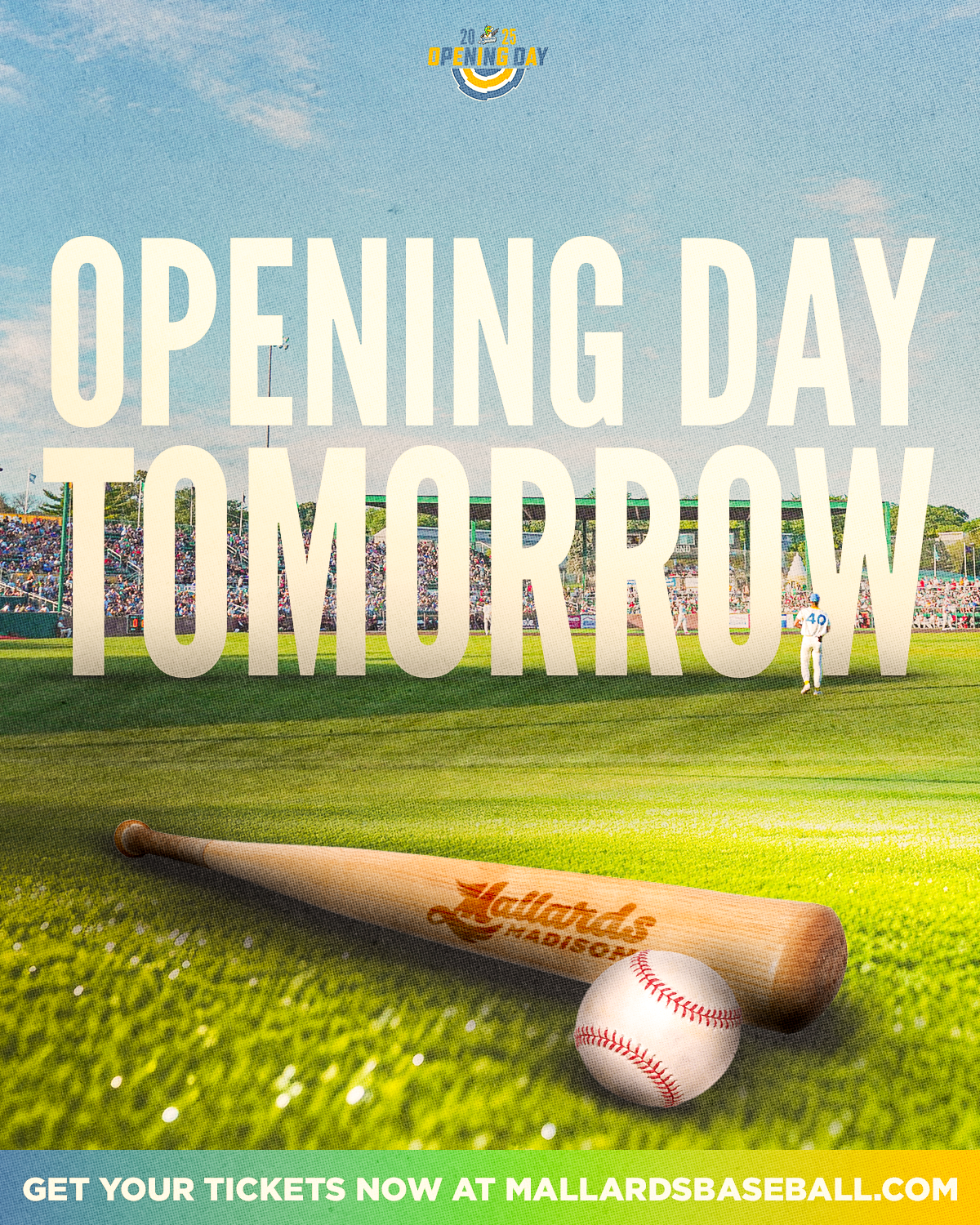 A promotional sign for Mallard's Baseball features a large baseball bat and ball in the foreground, a baseball field and player in the background, and a packed stadium with spectators. The text on the sign states 'Opening Day Tomorrow' and indicates 
