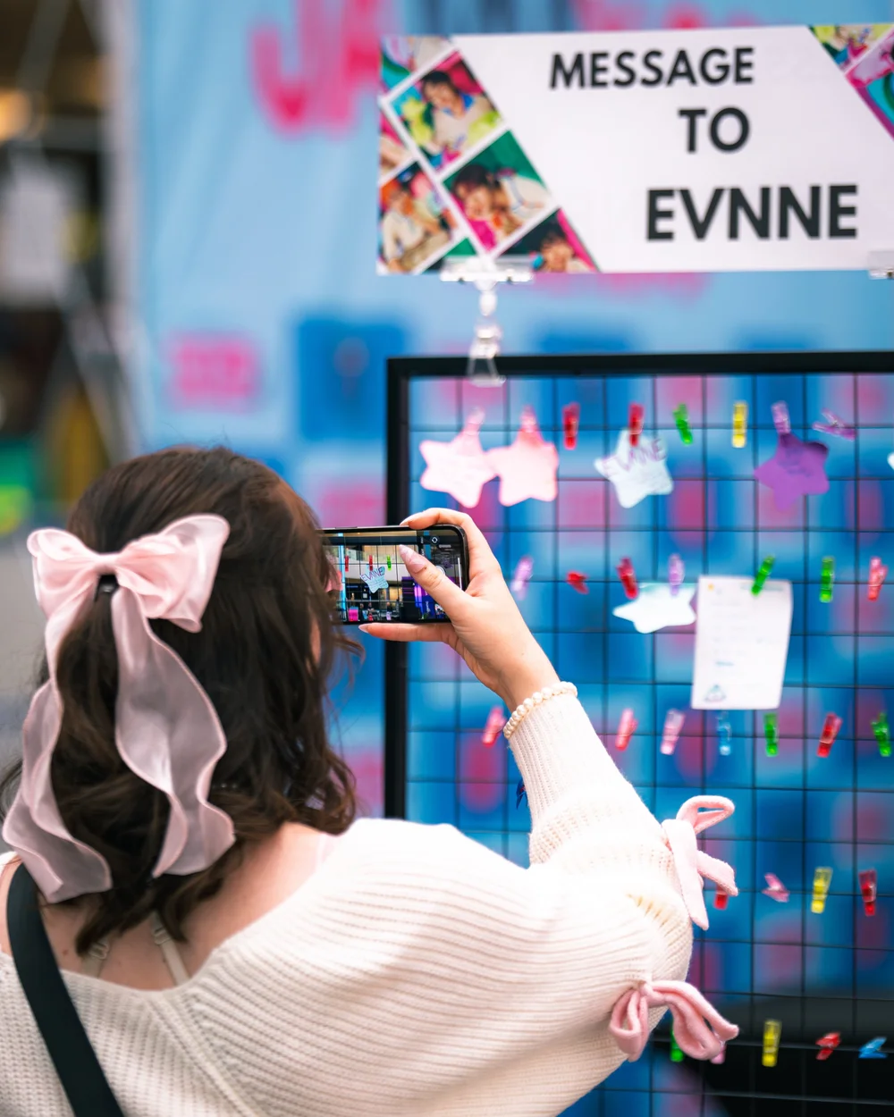 An attendee taking a photo at a JAMMY CON message wall