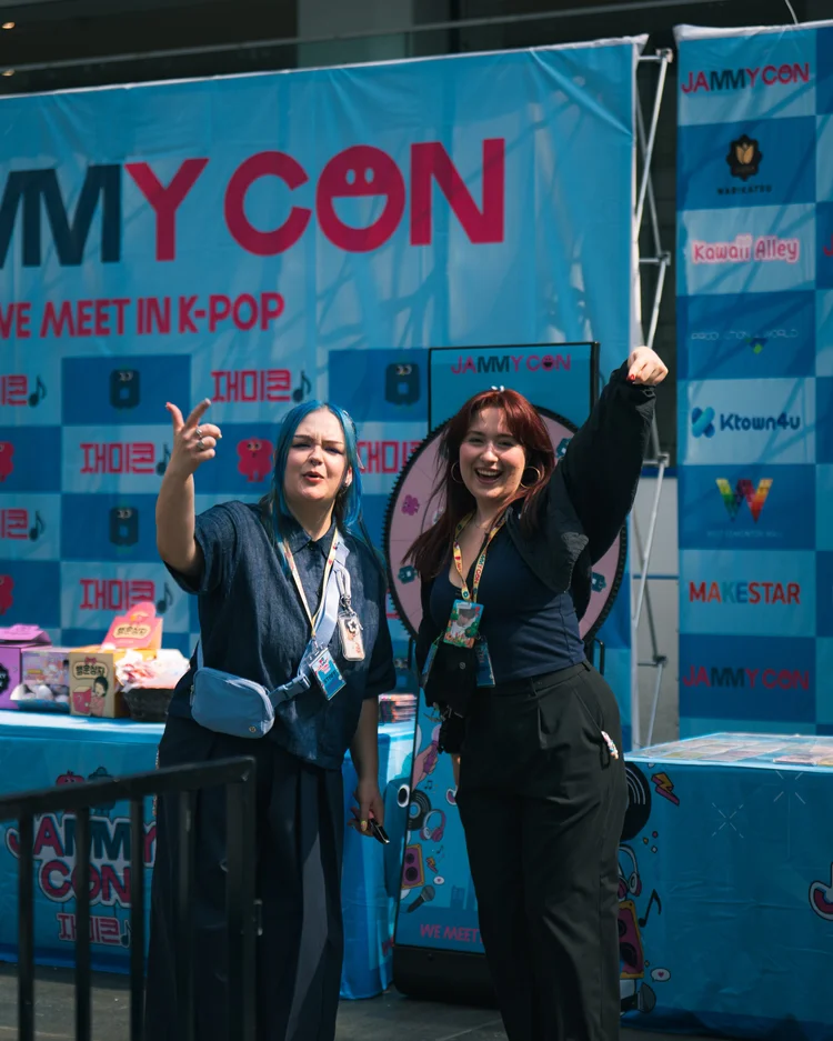 JAMMY CON staff welcoming attendees near an event booth