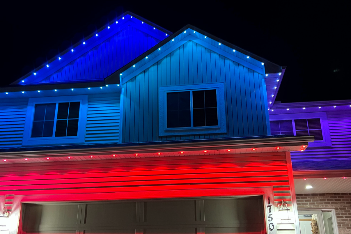 Christmas lighting installation on a Madison home with full roofline red and green display