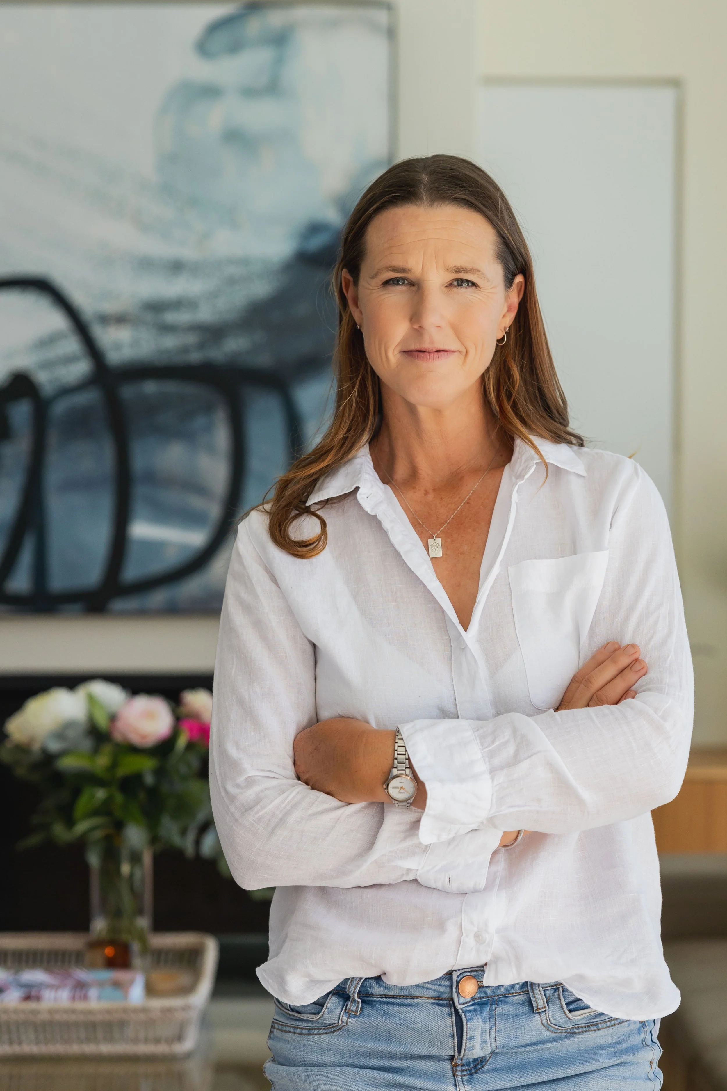 Portrait of Lucy Peel, founder of Lucy Peel Human Design, wearing a white linen shirt and watch, looking at the camera.