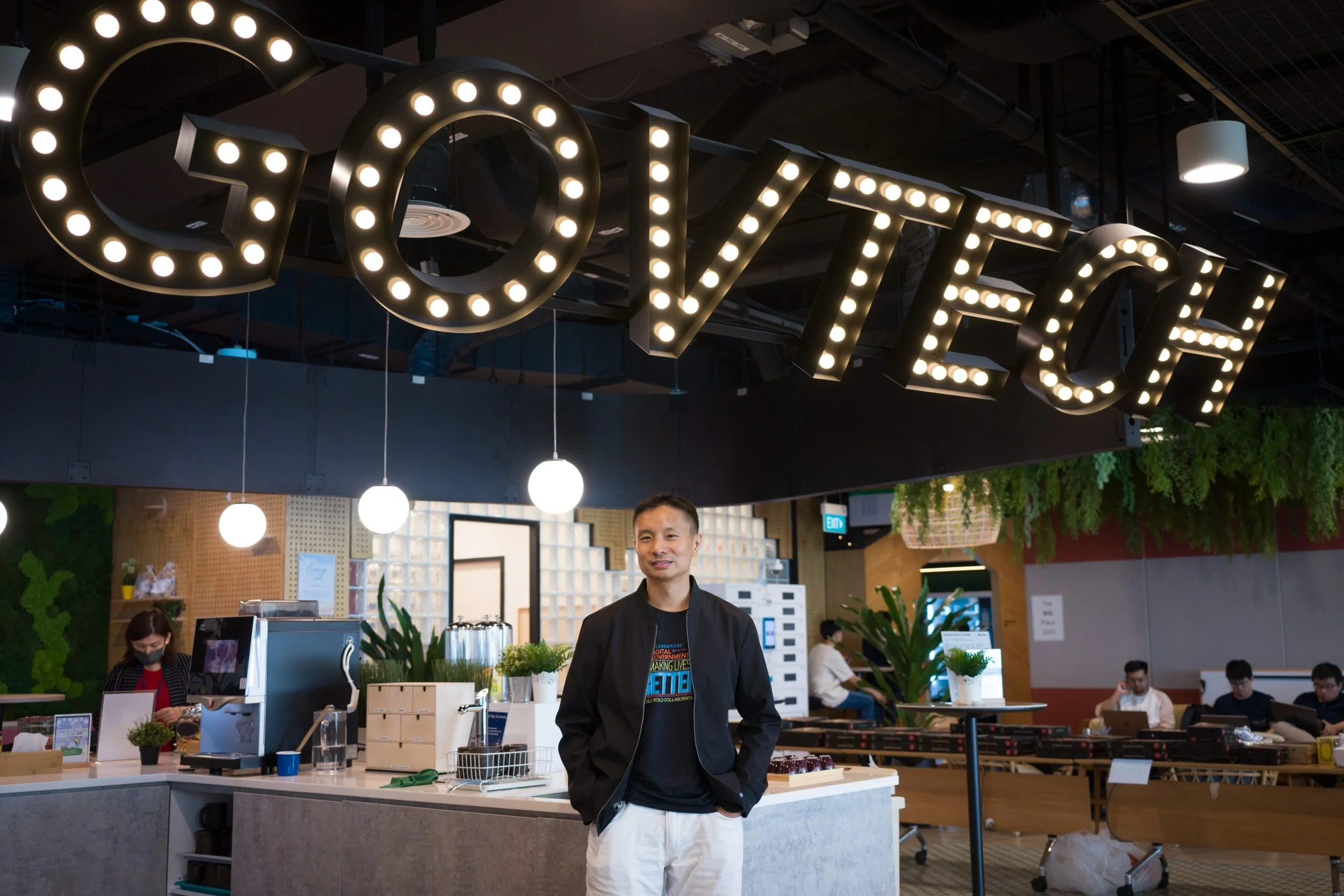 A man stands beneath an illuminated "GOVTECH" sign at Singapore's Government Technology Agency offices
