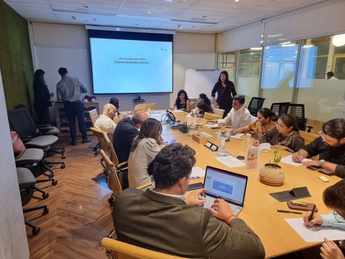 Leadership team working through a facilitated business evaluation exercise in a conference room, reviewing cross-industry insights and translating learning into practical decisions and execution priorities.