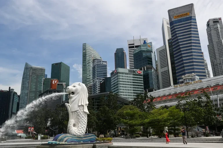 Singapore Merlion statue spouting water in front of modern skyscrapers in downtown Singapore. Learning Expedition
