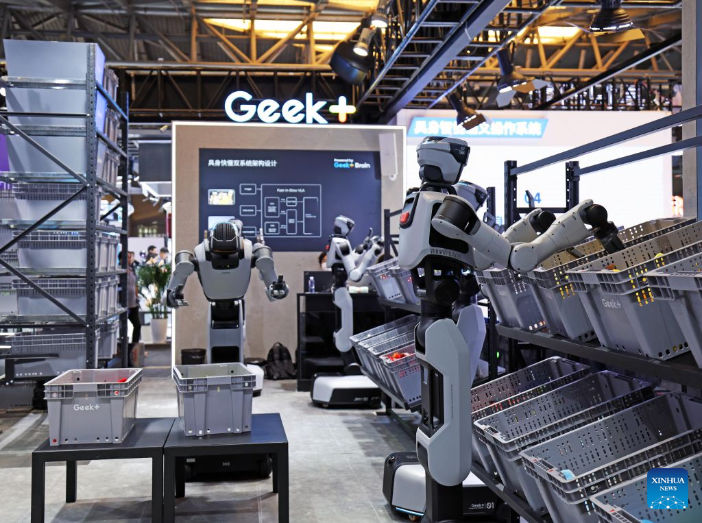 Humanoid warehouse robots by Chinese robotics company Geek+ picking items from storage bins at a trade show