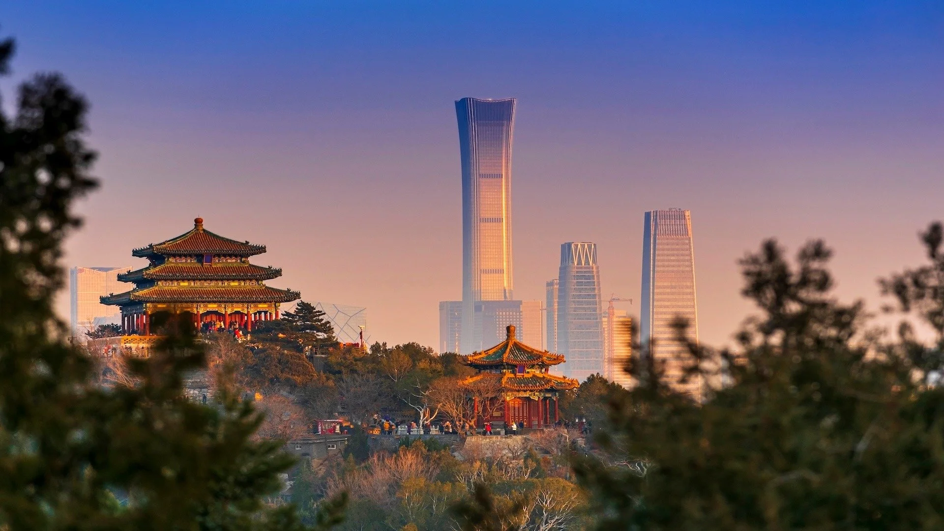 Traditional Chinese pagodas on a hill with modern skyscrapers in the background during sunset. Learning Expedition