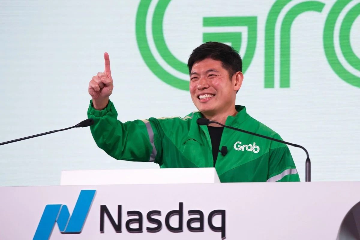 Grab co-founder and CEO Anthony Tan celebrates at the Nasdaq podium