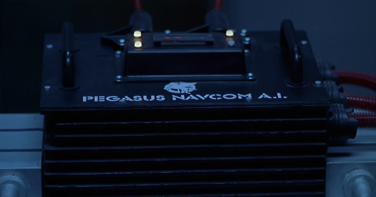 Image of the Pegasus NavCom AI - a black shoebox sized device with flexy-hoses running into it