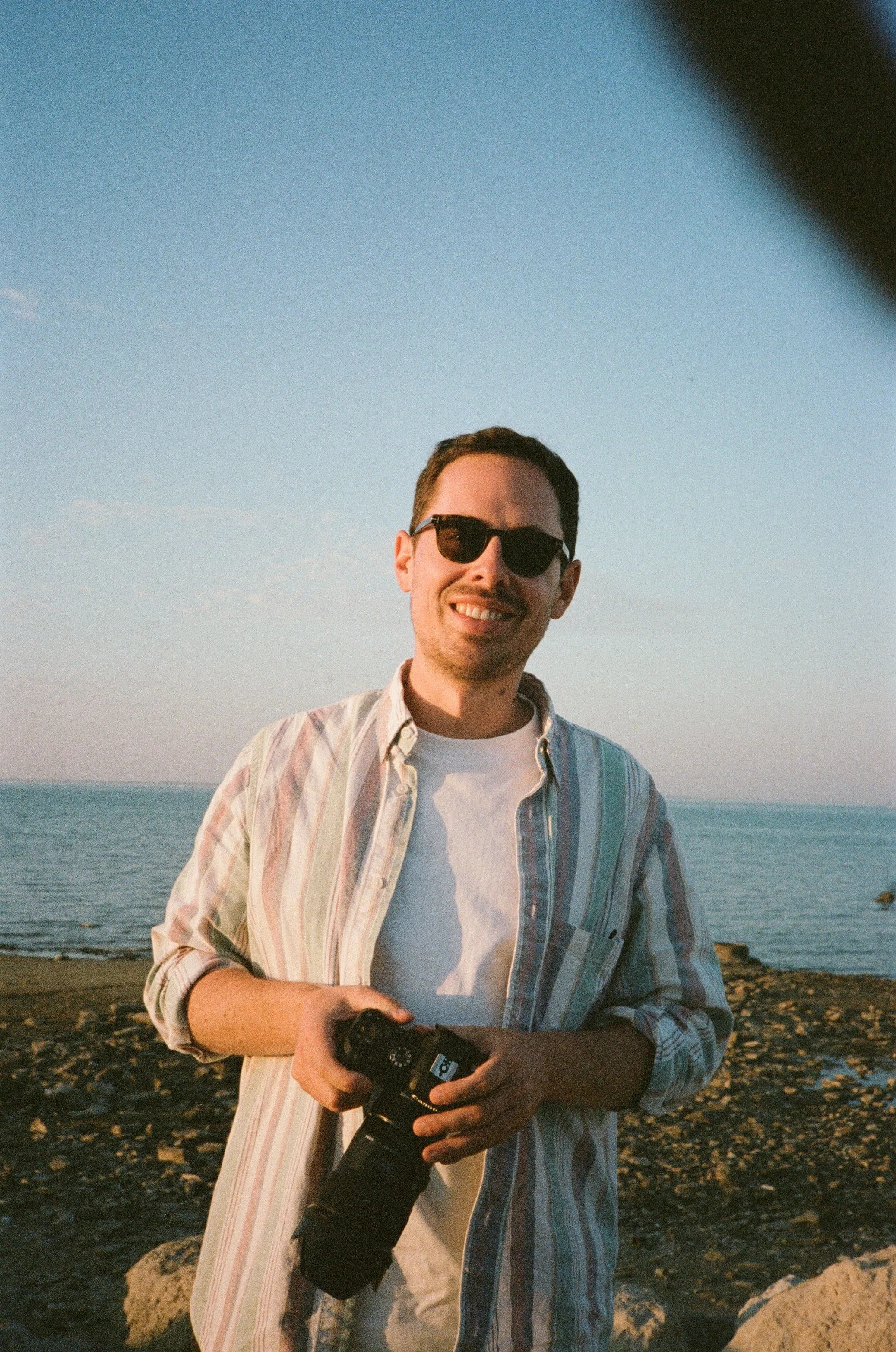 Portrait de Max De Hulster sur l'île de Ré avec son appareil photo pour une séance avec une famille