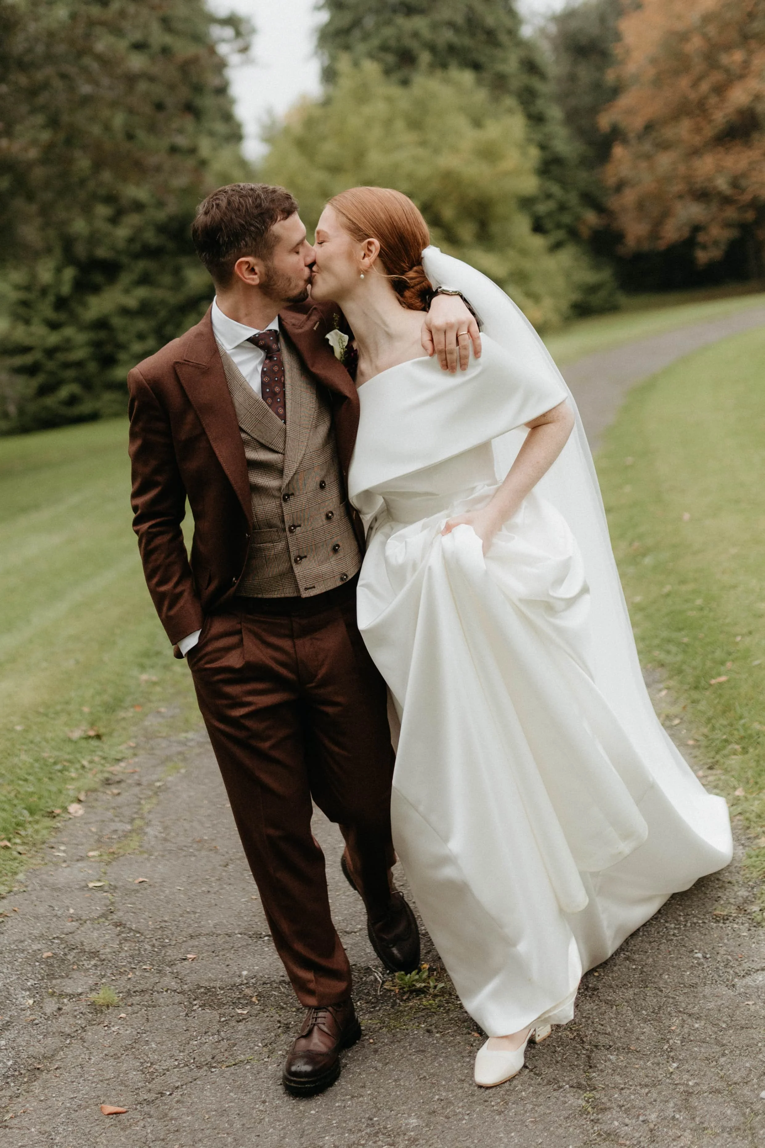 couple mariés s'embrassant tout en marchant sur le chemin vers le chateau