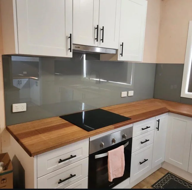 Custom glass kitchen splashback with vibrant colors, adding a modern and stylish touch to protect walls from spills and heat in the kitchen. Perfect for easy cleaning and a sleek design.