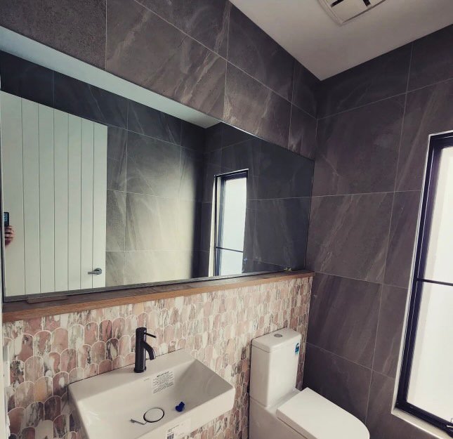 Elegant custom mirror installation, adding depth and brightness to the space. Ideal for enhancing room aesthetics and creating a spacious feel in homes, bathrooms, and commercial spaces.