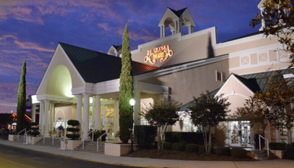 Large theater building with illuminated sign and entrance at dusk