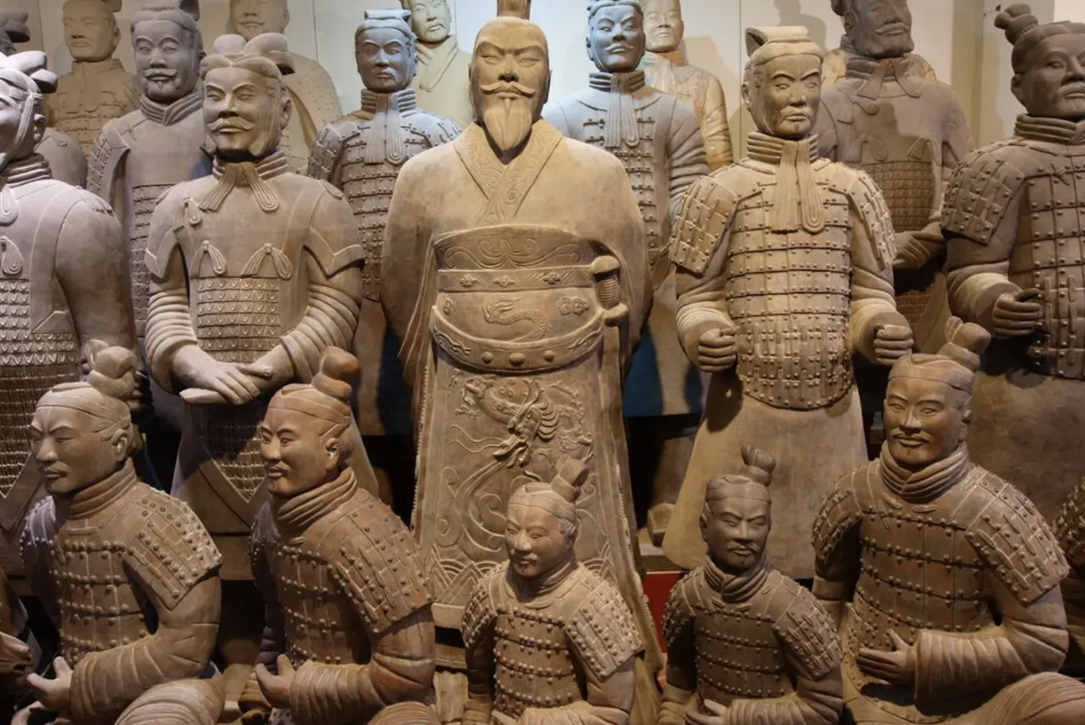 Group of terracotta soldiers, some standing and some kneeling, in a museum display.