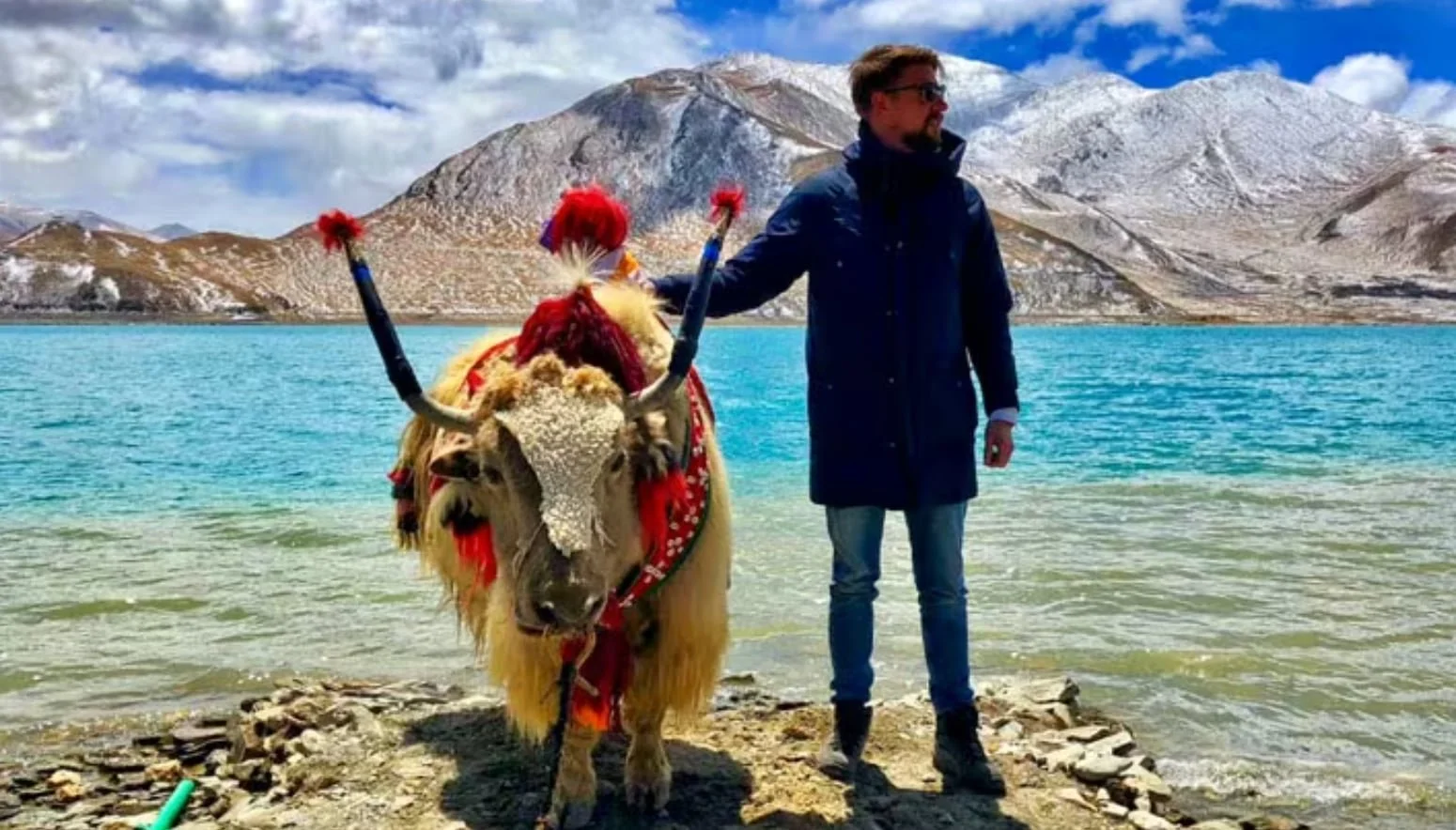tibet travel guide 2026 yak and man on the edge of a lake