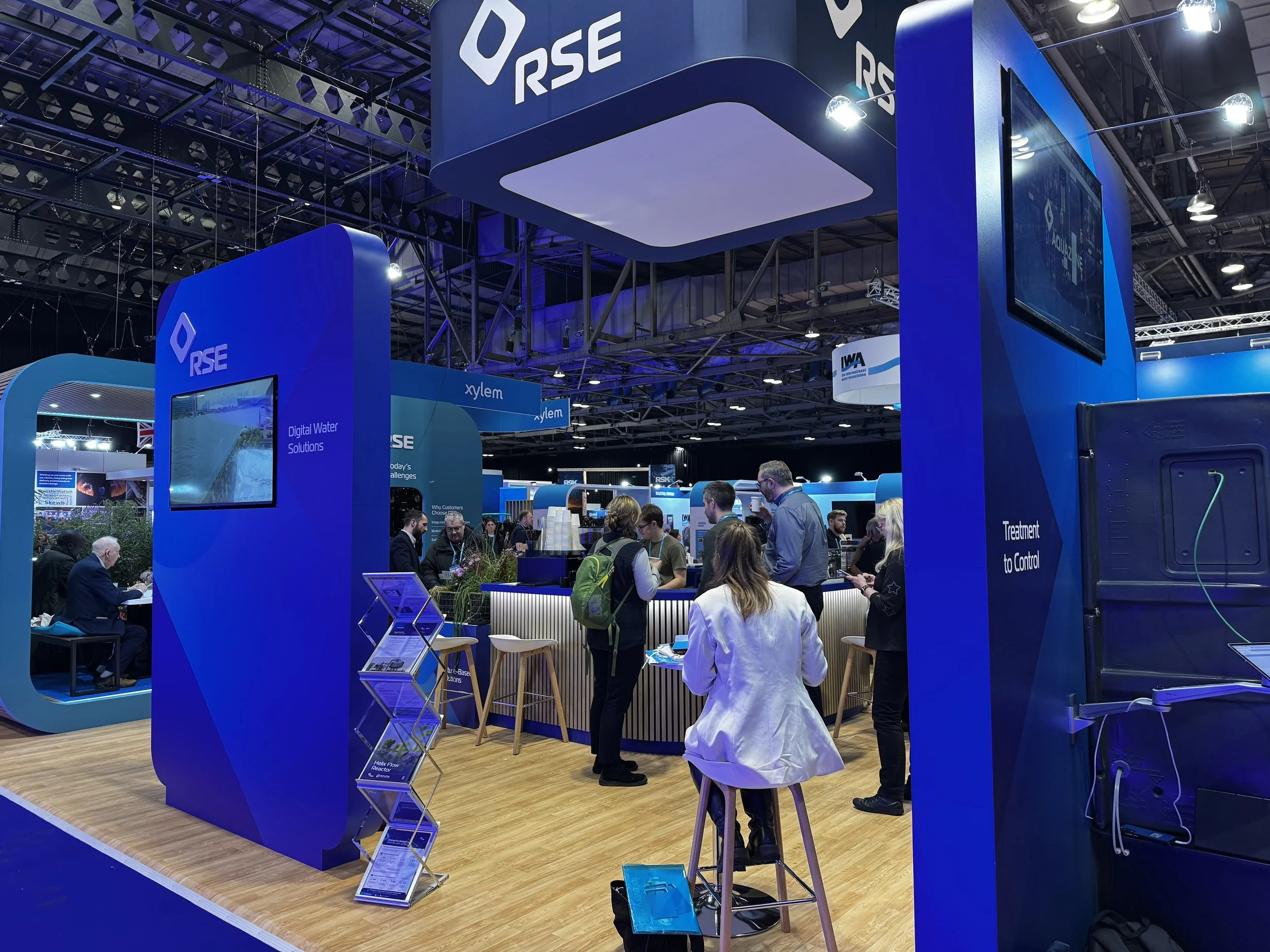 Visitors gather around the Kart Coffee mobile coffee bar on the RSE stand at the IWA World Water Congress 2026, SEC Glasgow