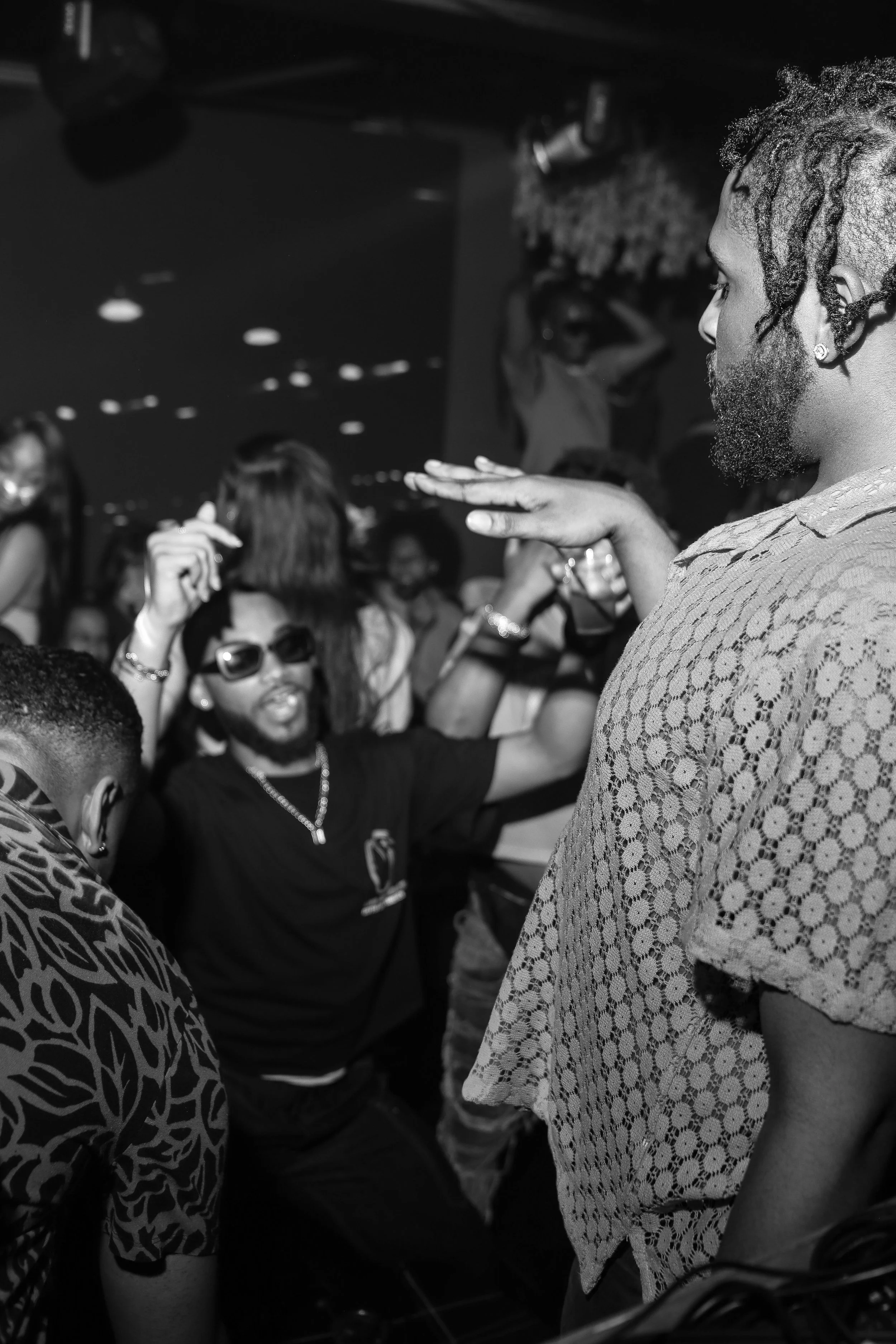 People dancing and enjoying themselves in a club or party setting, black and white photo.