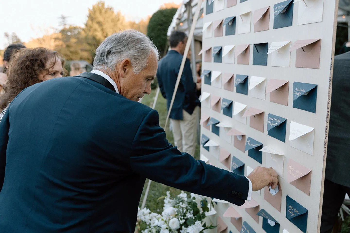 As guests arrive at an enchanting outdoor tented wedding, they are invited to begin their journey at the vibrant escort wall&mdash;a kaleidoscope of colors and personalized touches. Imagine stepping up to this beautifully curated display, where each 