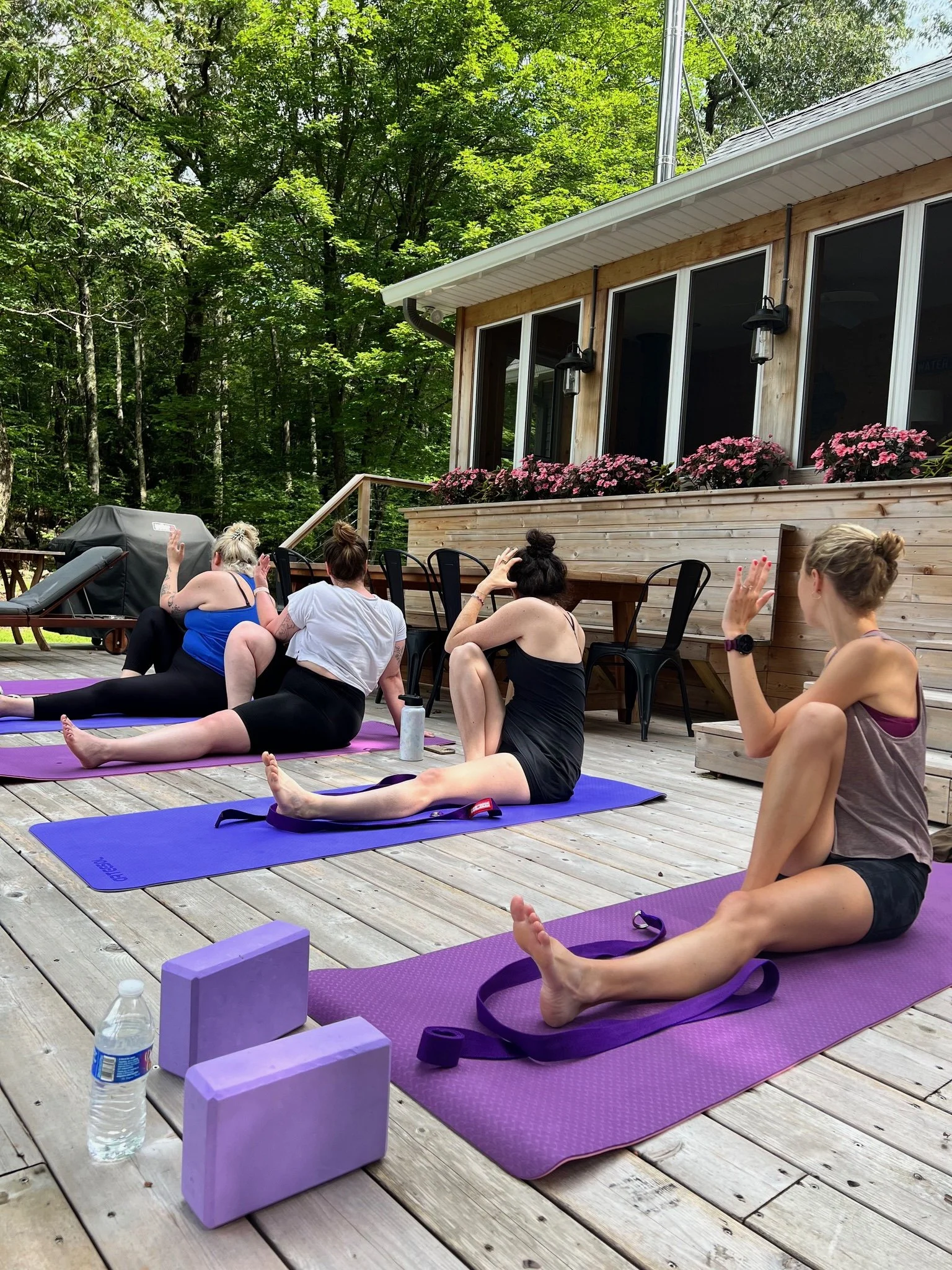 Private Wedding Group Class of Yoga students practicing a seated twist  at serene location in Woodstock, NY.