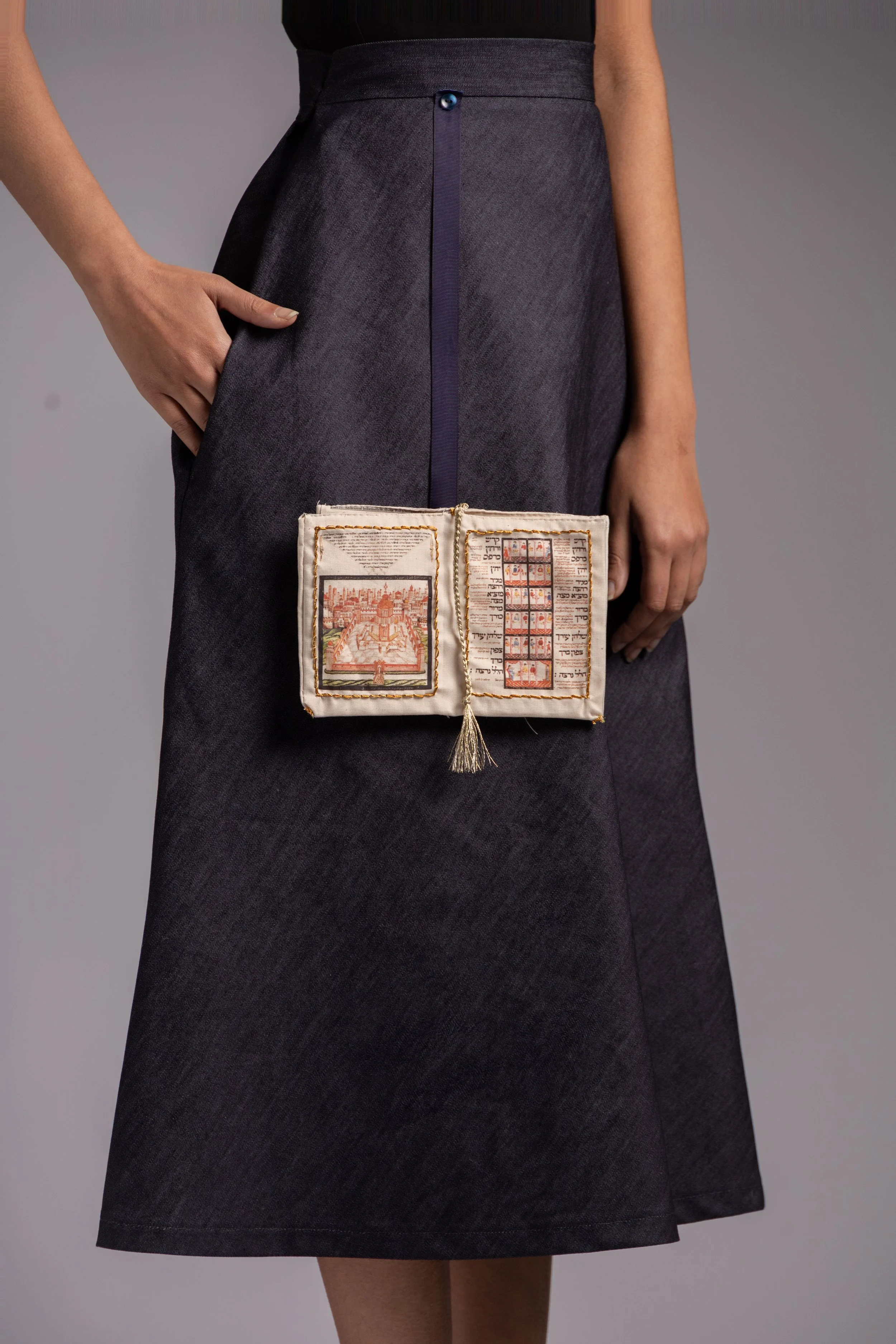 Detachable fabric book detail printed on calico attached to navy denim skirt.