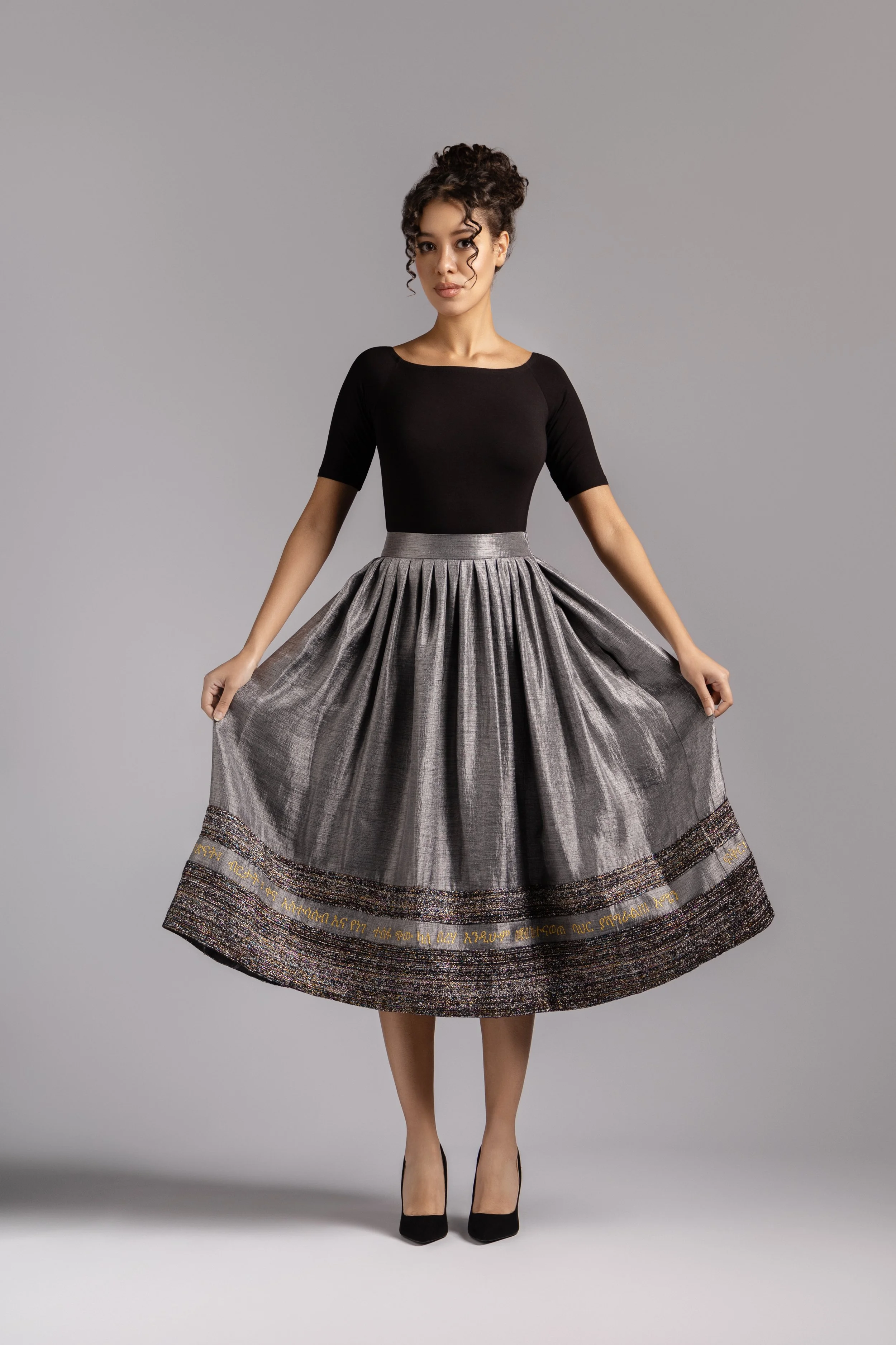 Grey pleated midi skirt with full 1950s-inspired silhouette.
