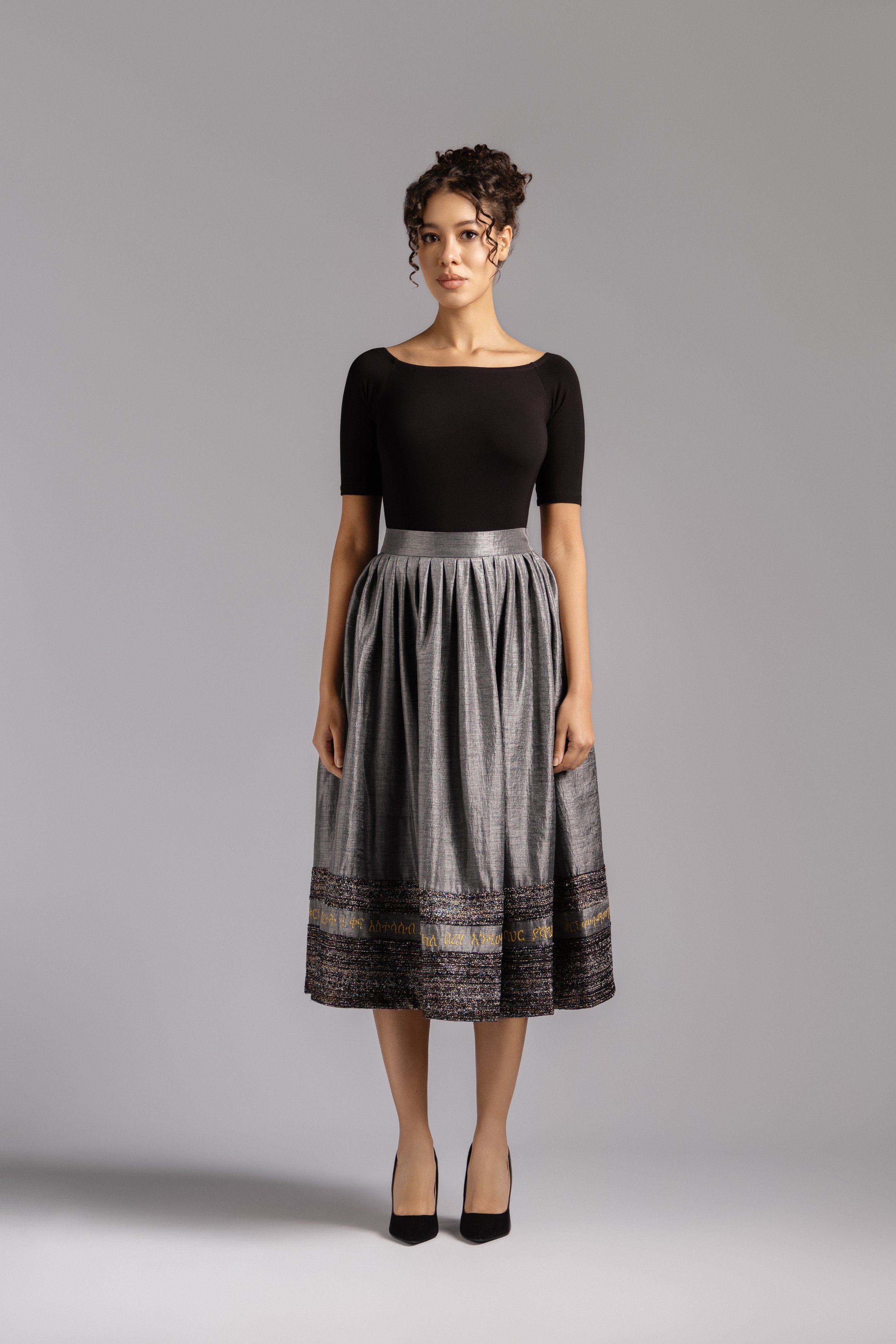Statement grey pleated skirt inspired by Ethiopian heritage.