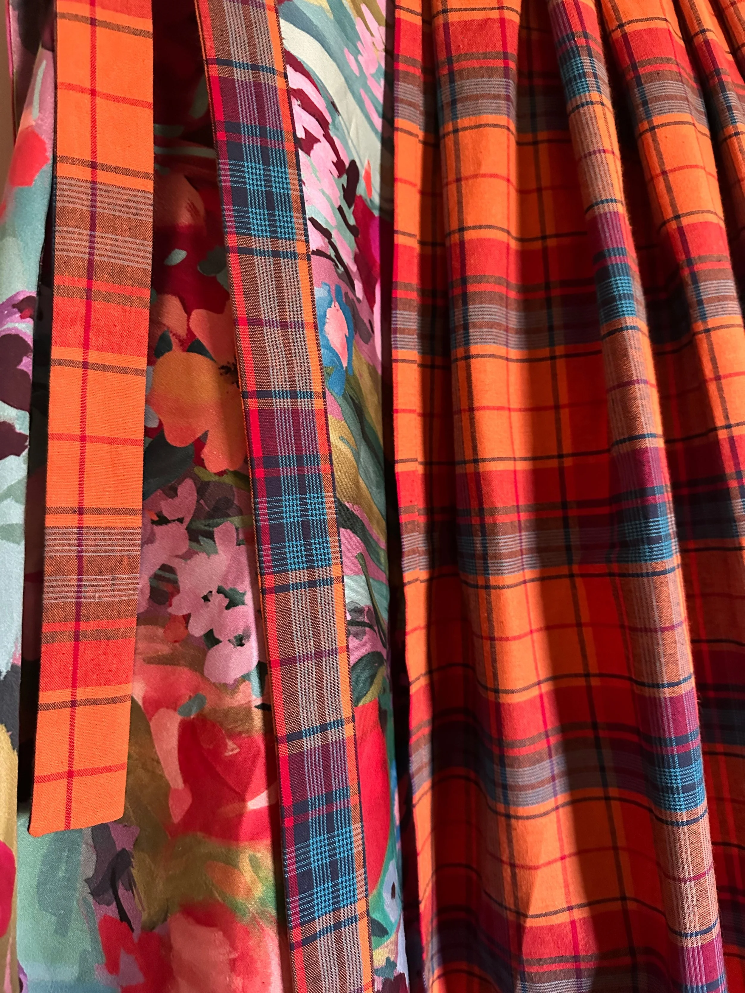 Close-up detail of reversible wrap skirt with floral and madras cotton fabrics.
